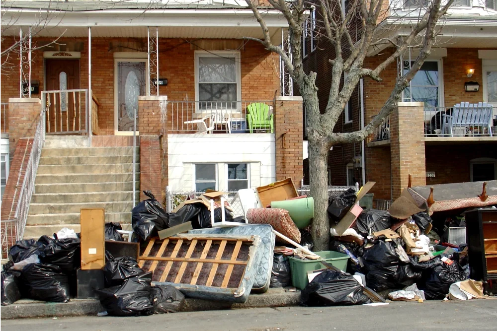 Piles of beds, and garbage outside homes