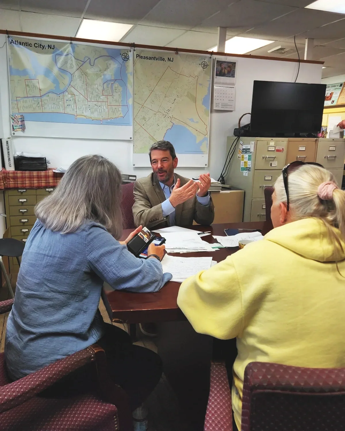 An attorney speaks as two women take notes