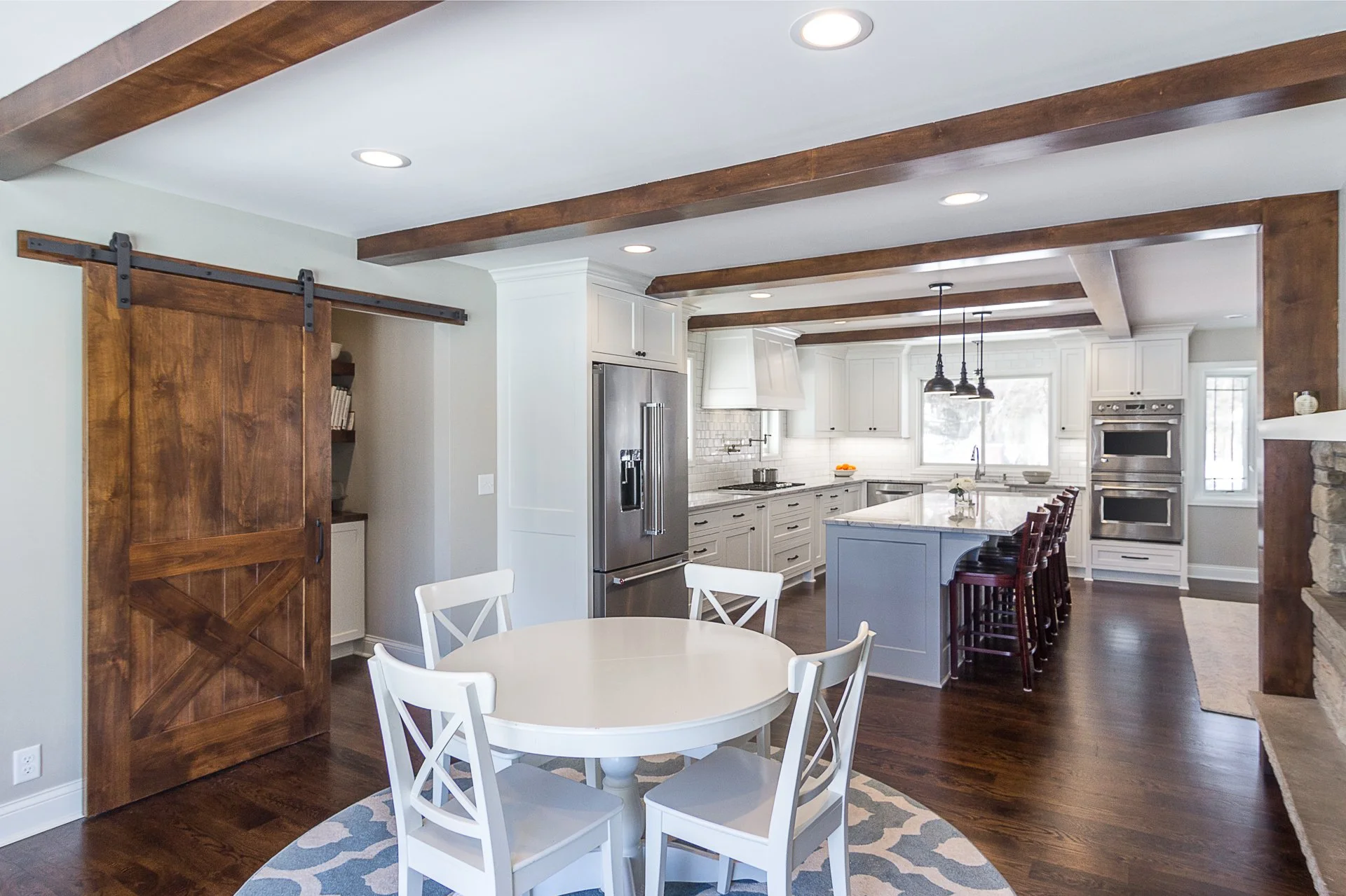 Edina custom kitchen remodel, white cabinets, quartzite countertops, rustic wooden beams, black pendant lights.