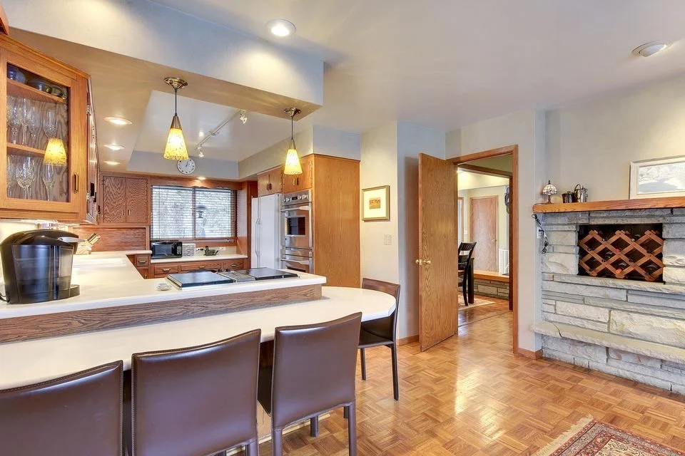 original Edina kitchen, with dated wood cabinets, soffit, much darker and less open