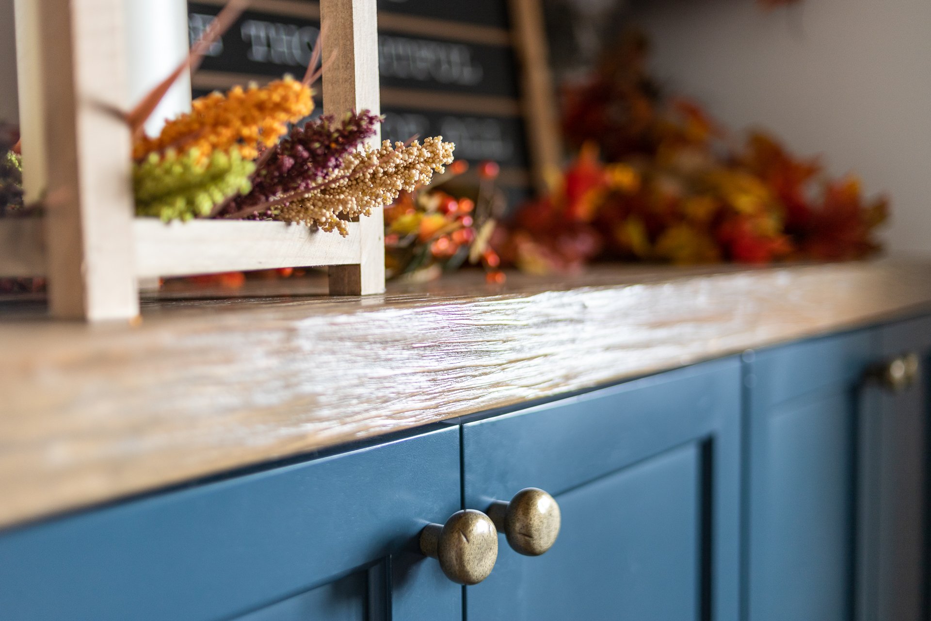 Close-up of blue custom cabinetry with decorative brass cabinet knobs