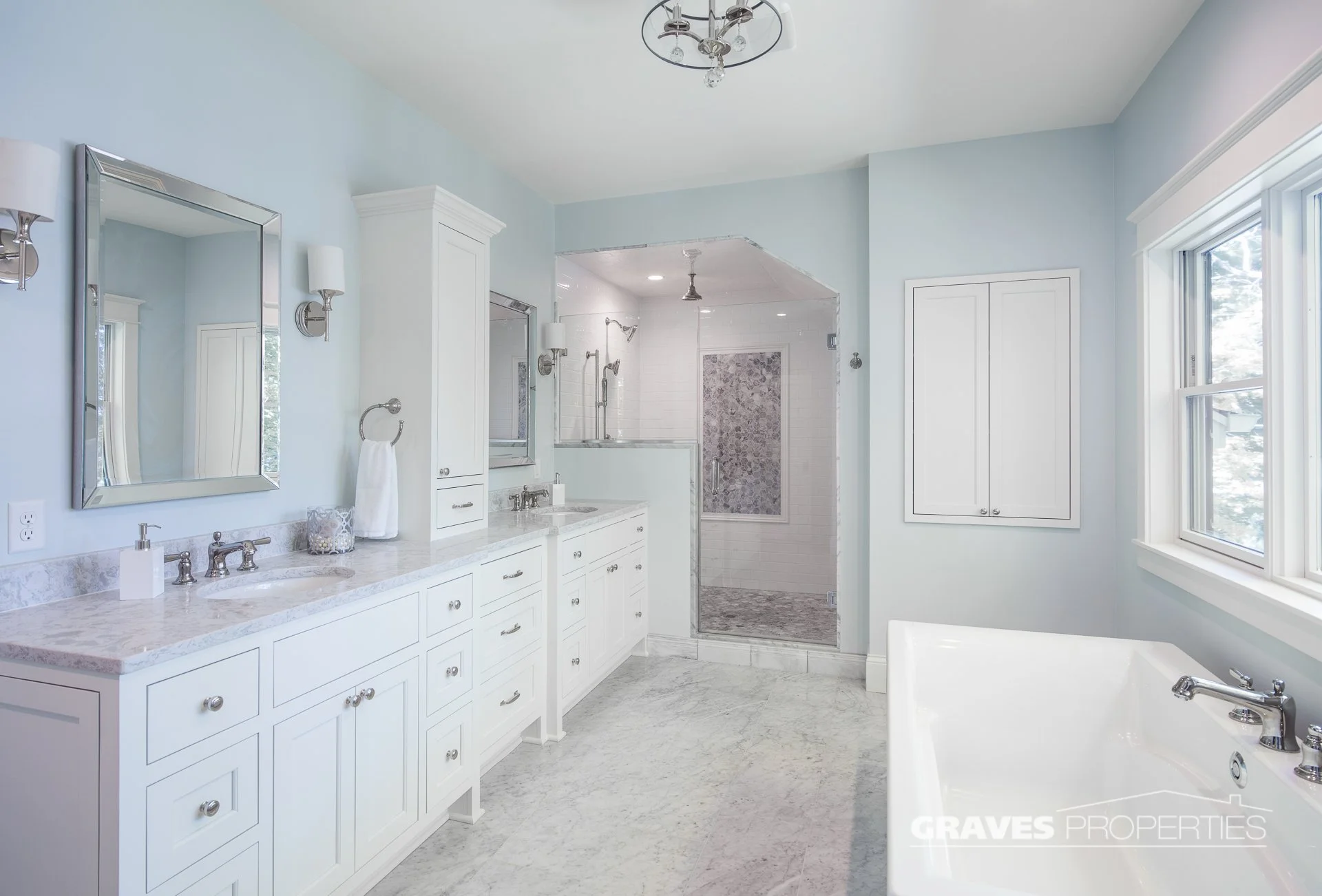 Light blue and white bathroom remodel, soaker tub, white marble shower, polished nickel hardware, Carrara marble countertops.