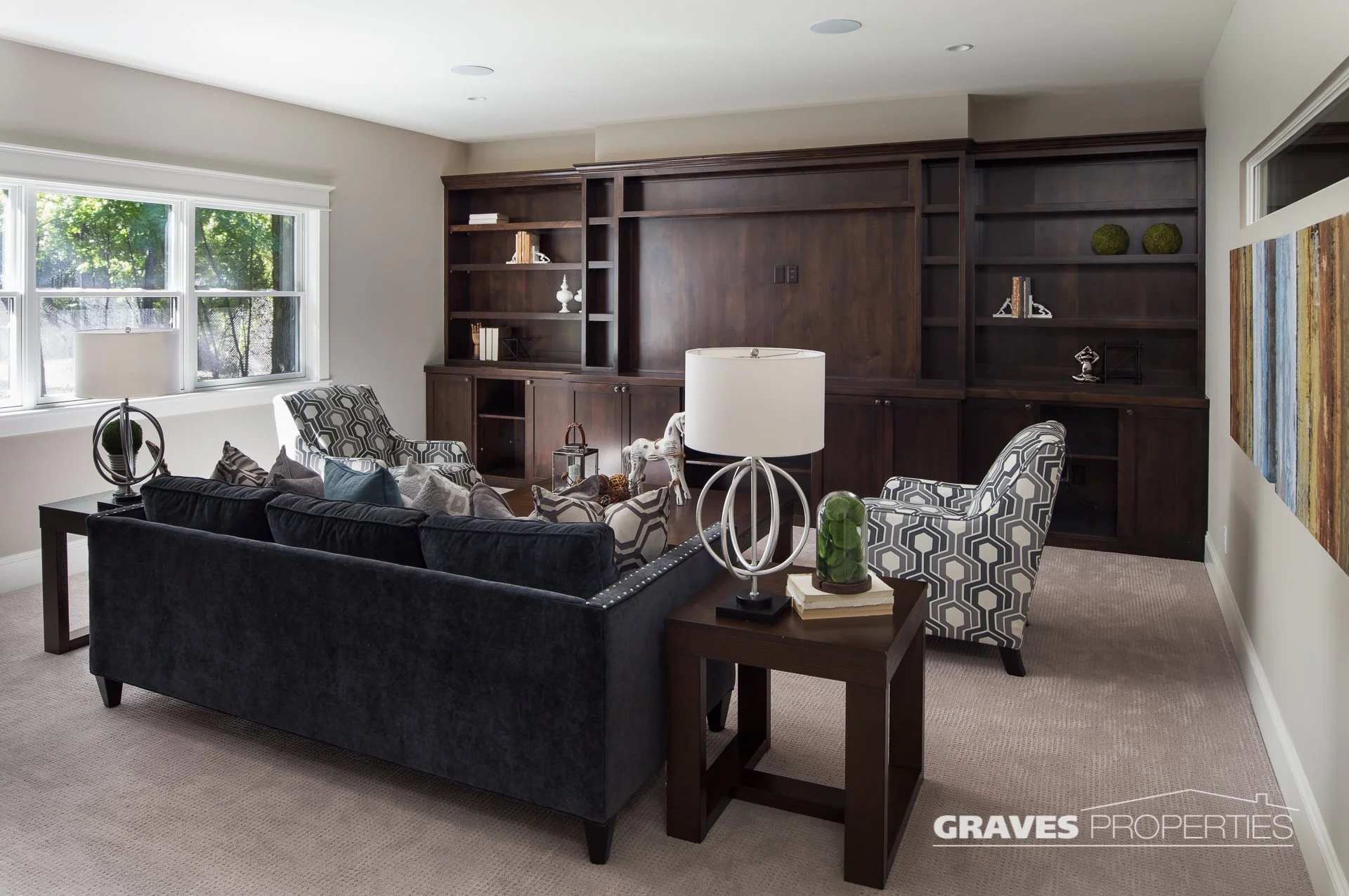 Family room with TV wall, including custom dark wood shelving.
