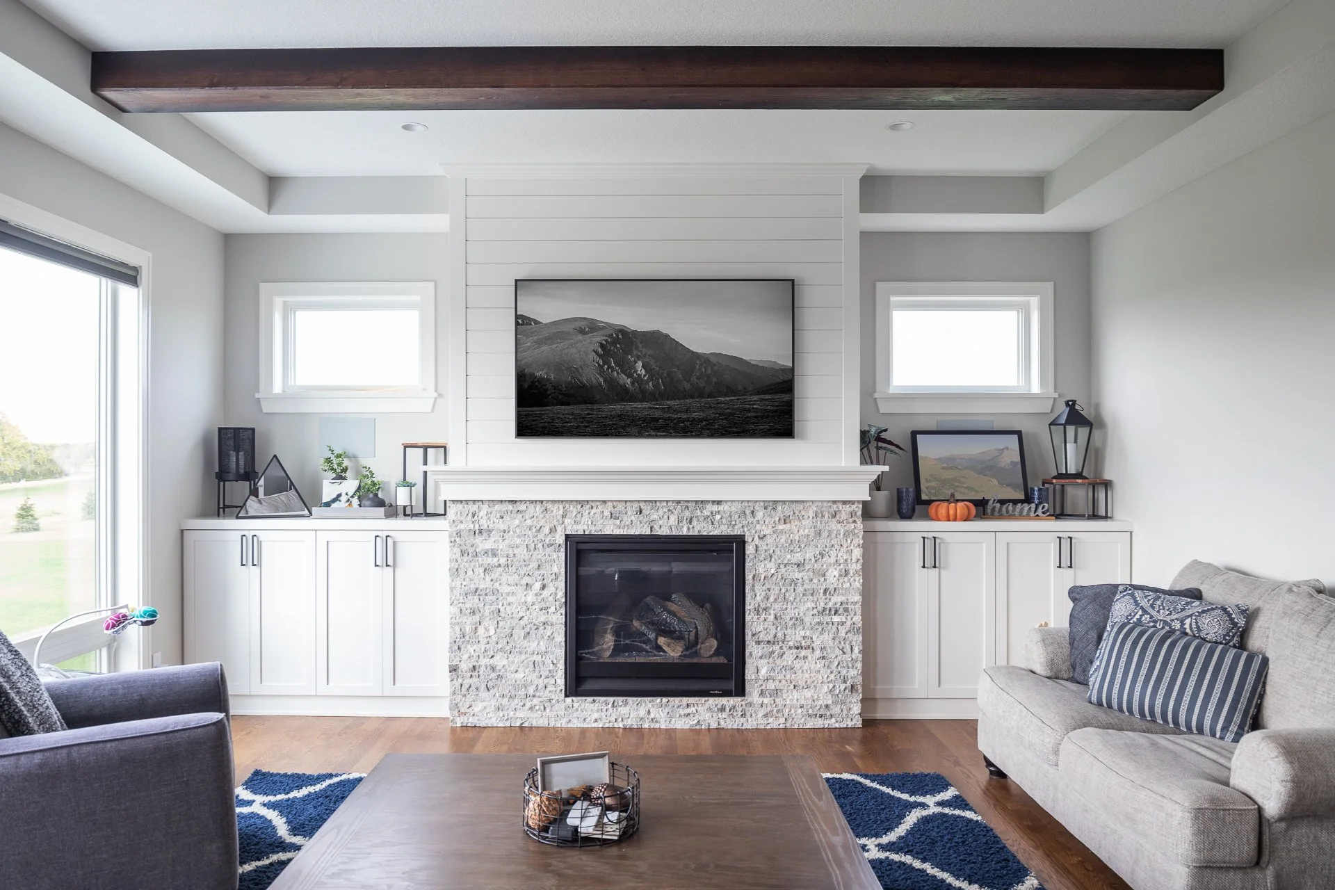 White built-in entertainment cabinets surrounding a fireplace and wall-mounted TV