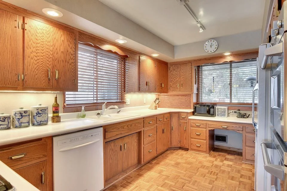 original Edina kitchen, with dated wood cabinets, soffit, much darker and less open