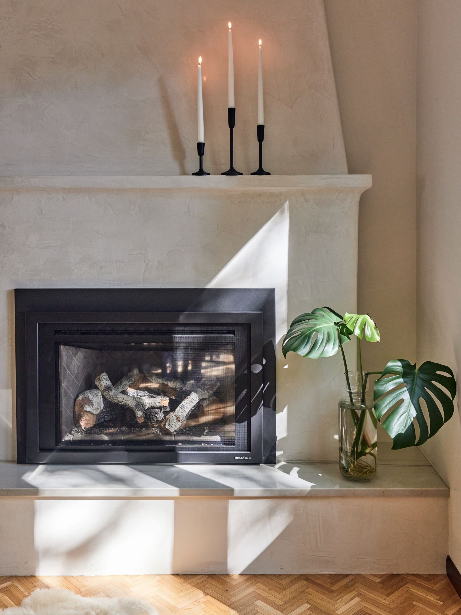 Golden Valley dining room, plaster custom fireplace, gas fireplace. black candlesticks, monstera plant 