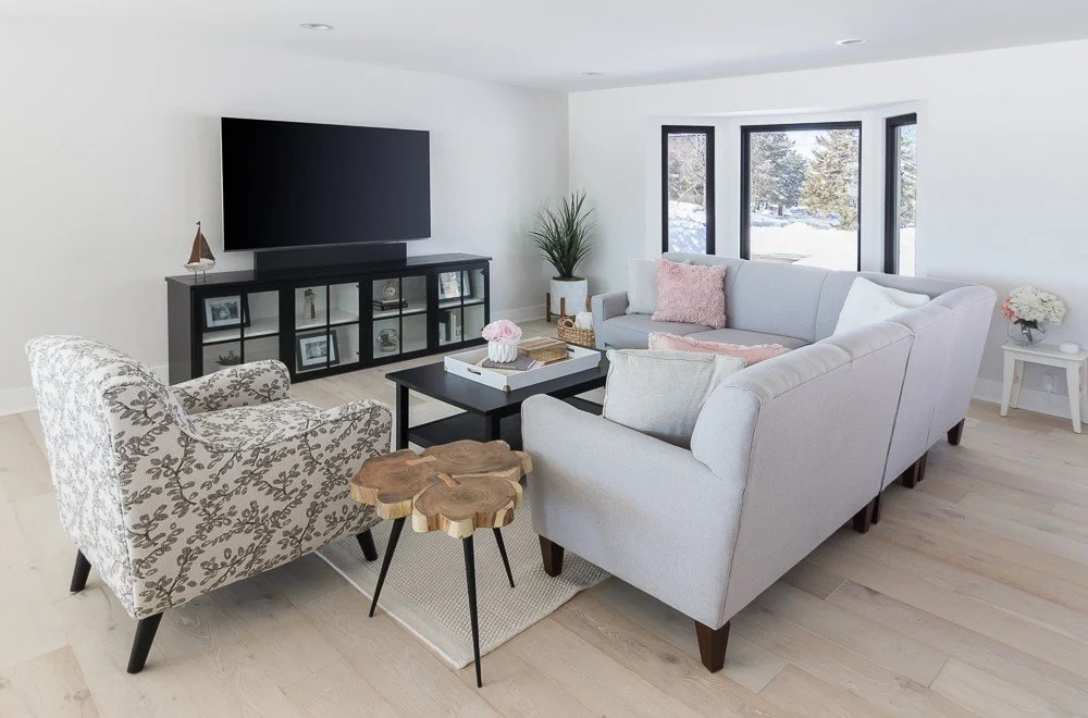 living room in Plymouth remodel, full of light. Black window trim, white walls.