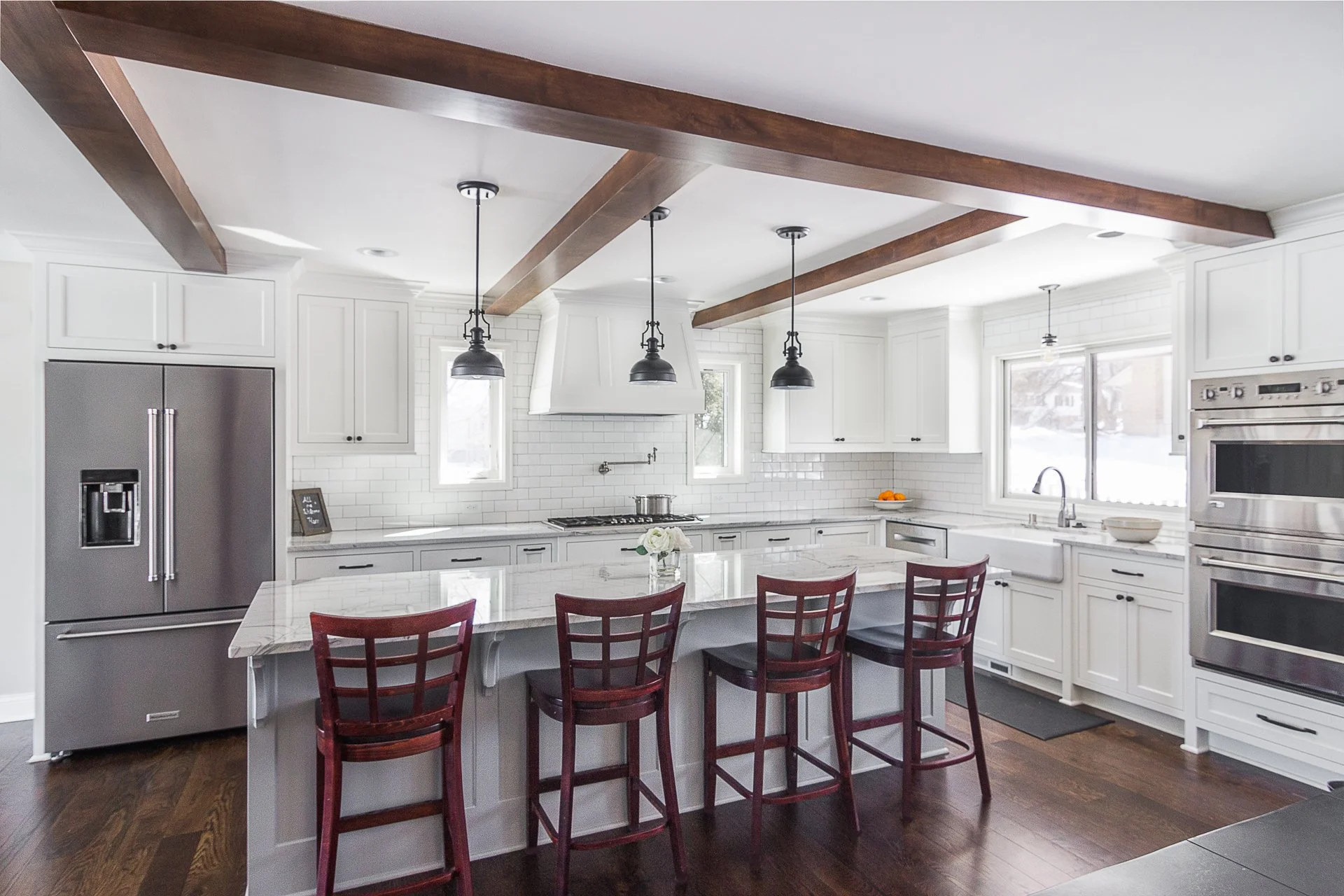 Edina custom kitchen remodel, white cabinets, quartzite countertops, rustic wooden beams, black pendant lights.