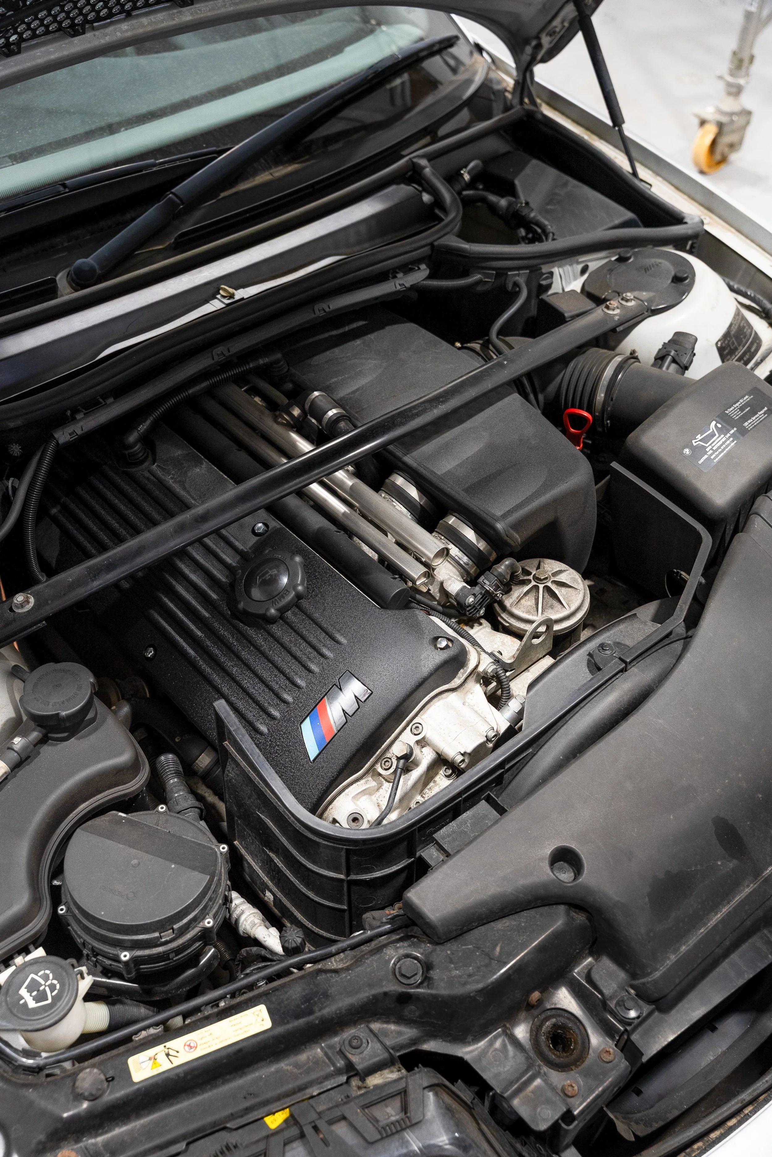 BMW E92 track car engine bay inspected as part of a vehicle health check