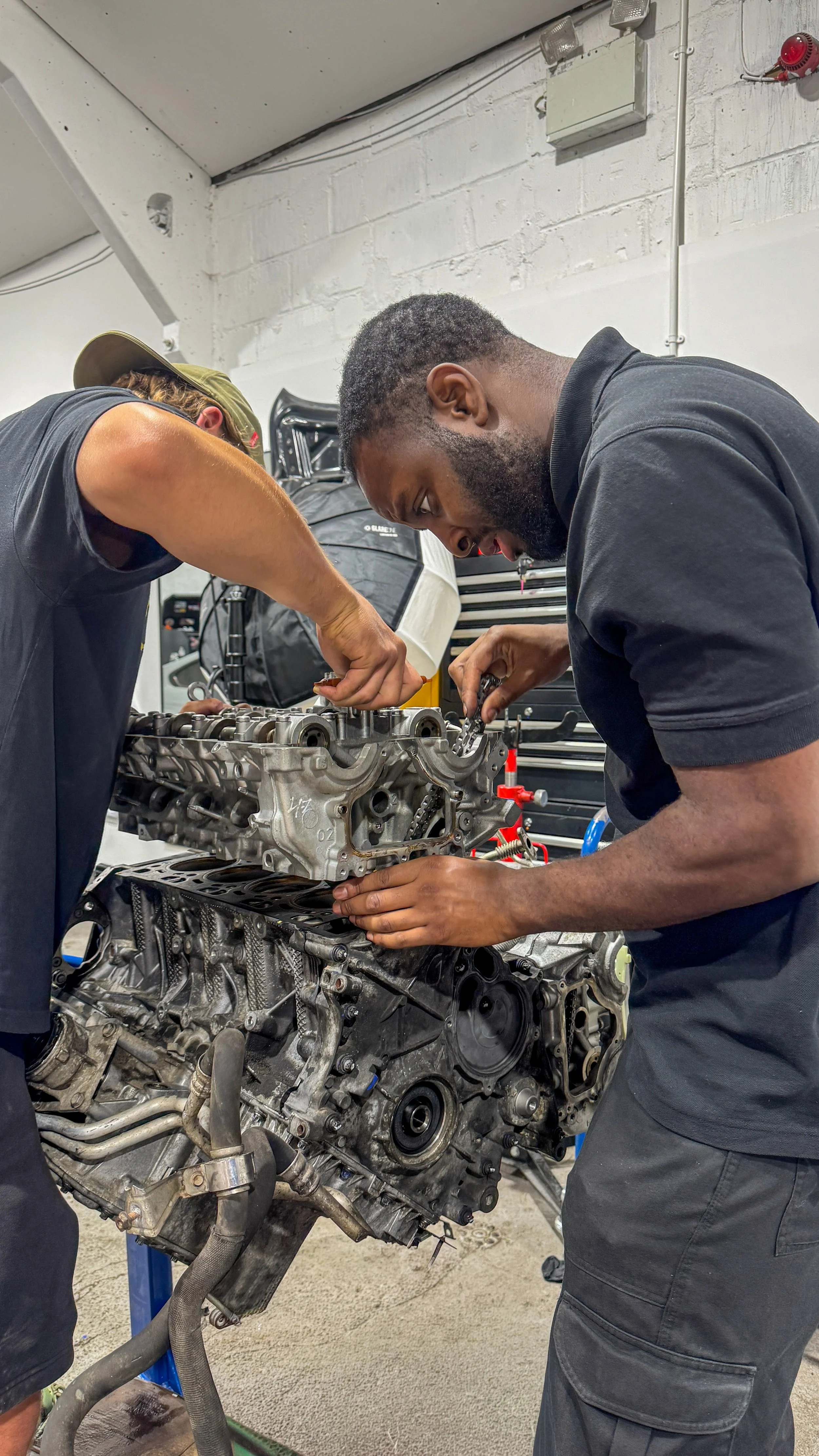 BMW X5 M engine rebuild in progress with technicians working on the timing chains