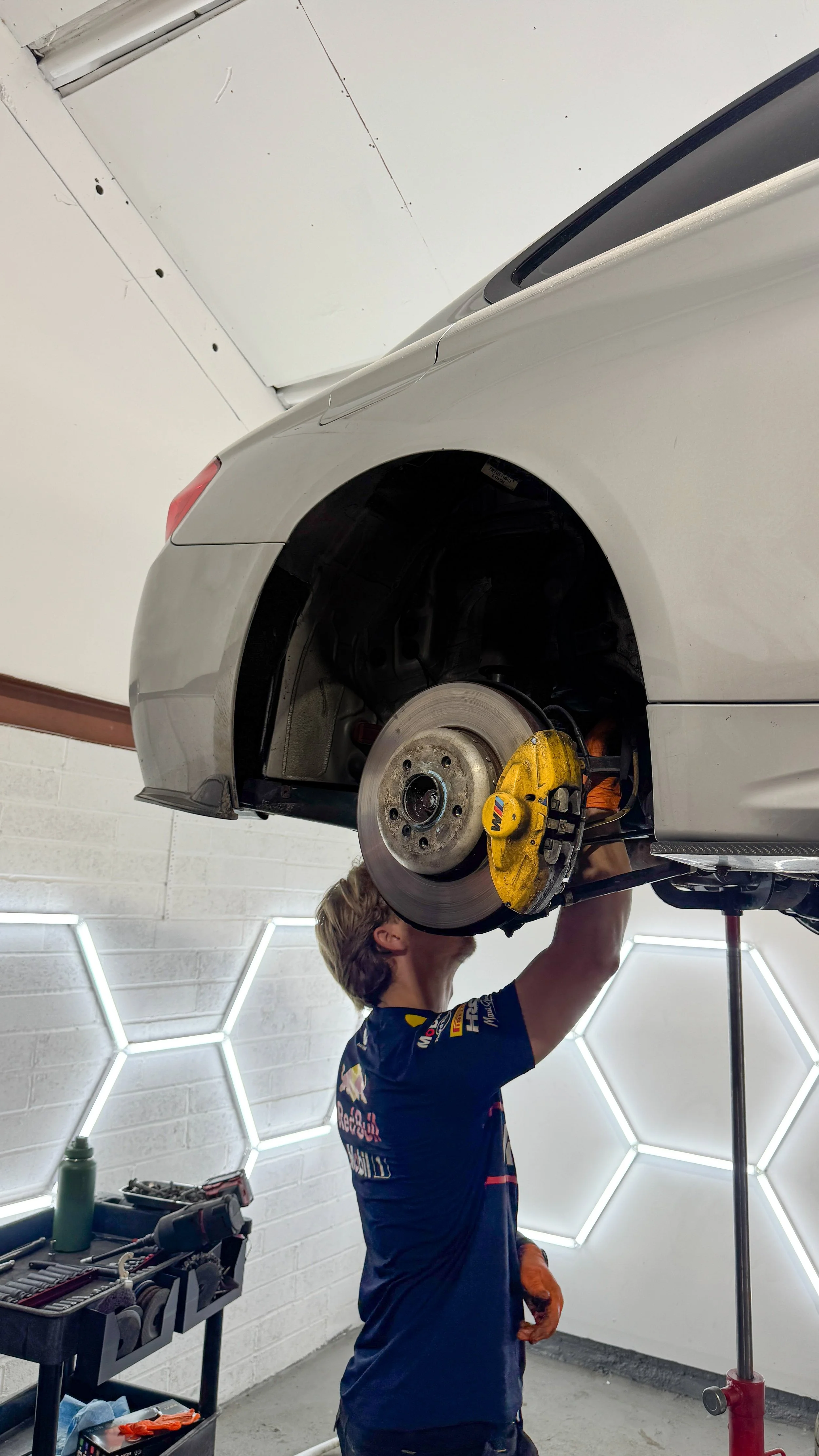 BMW 435I suspension work in progress with wheel removed, exposing the brake disc, caliper and wheel arch