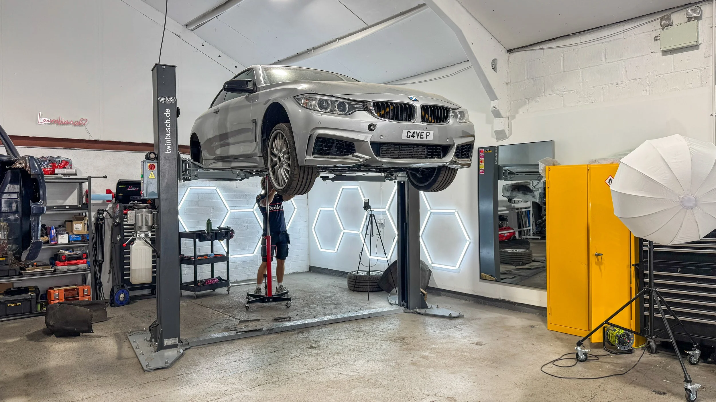 BMW 435i track car on a workshop ramp during suspension and bushing inspection