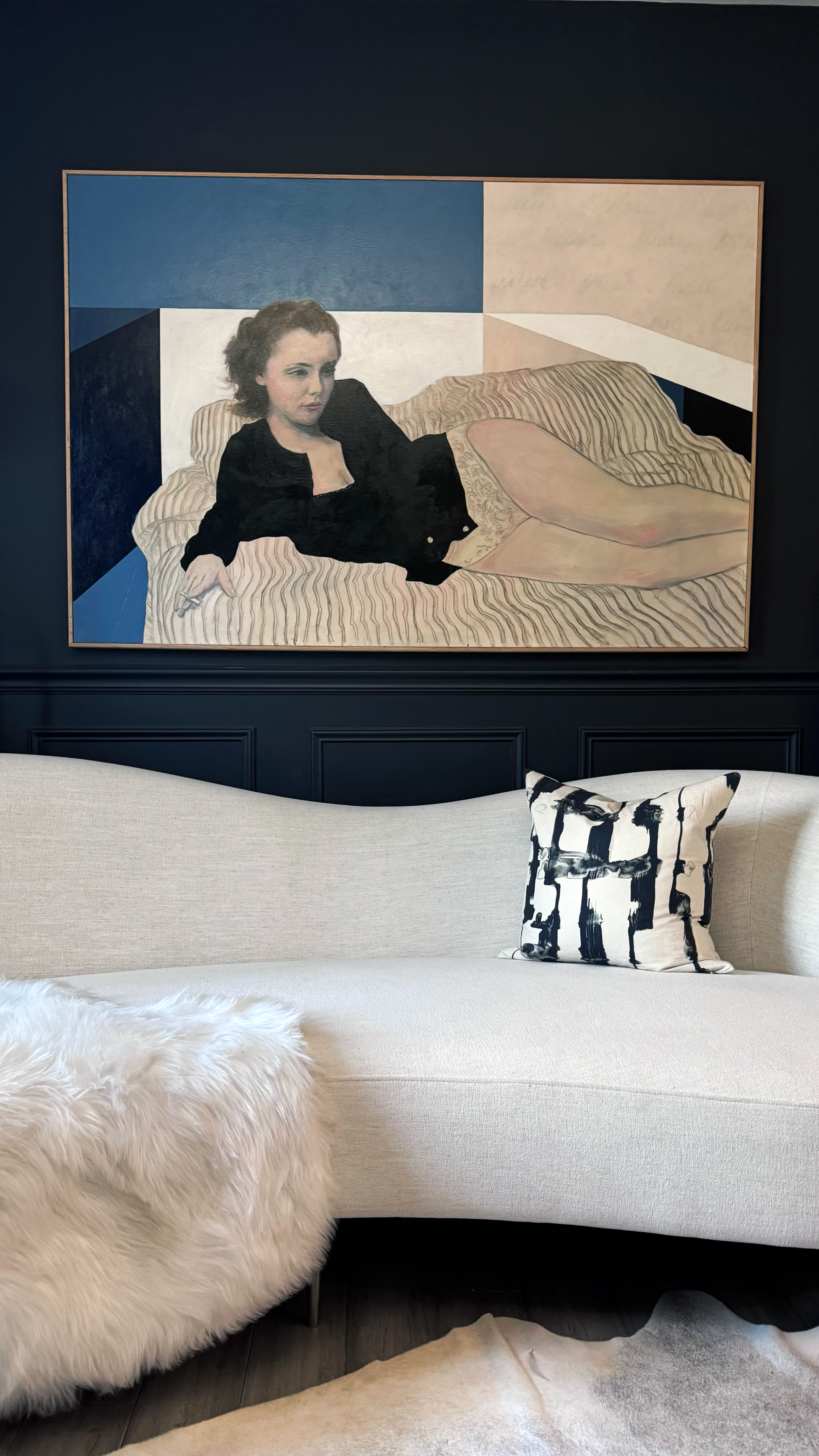 Large-scale figurative painting "Goddess II" by Shannon Boutilier displayed above a sofa in a contemporary interior.