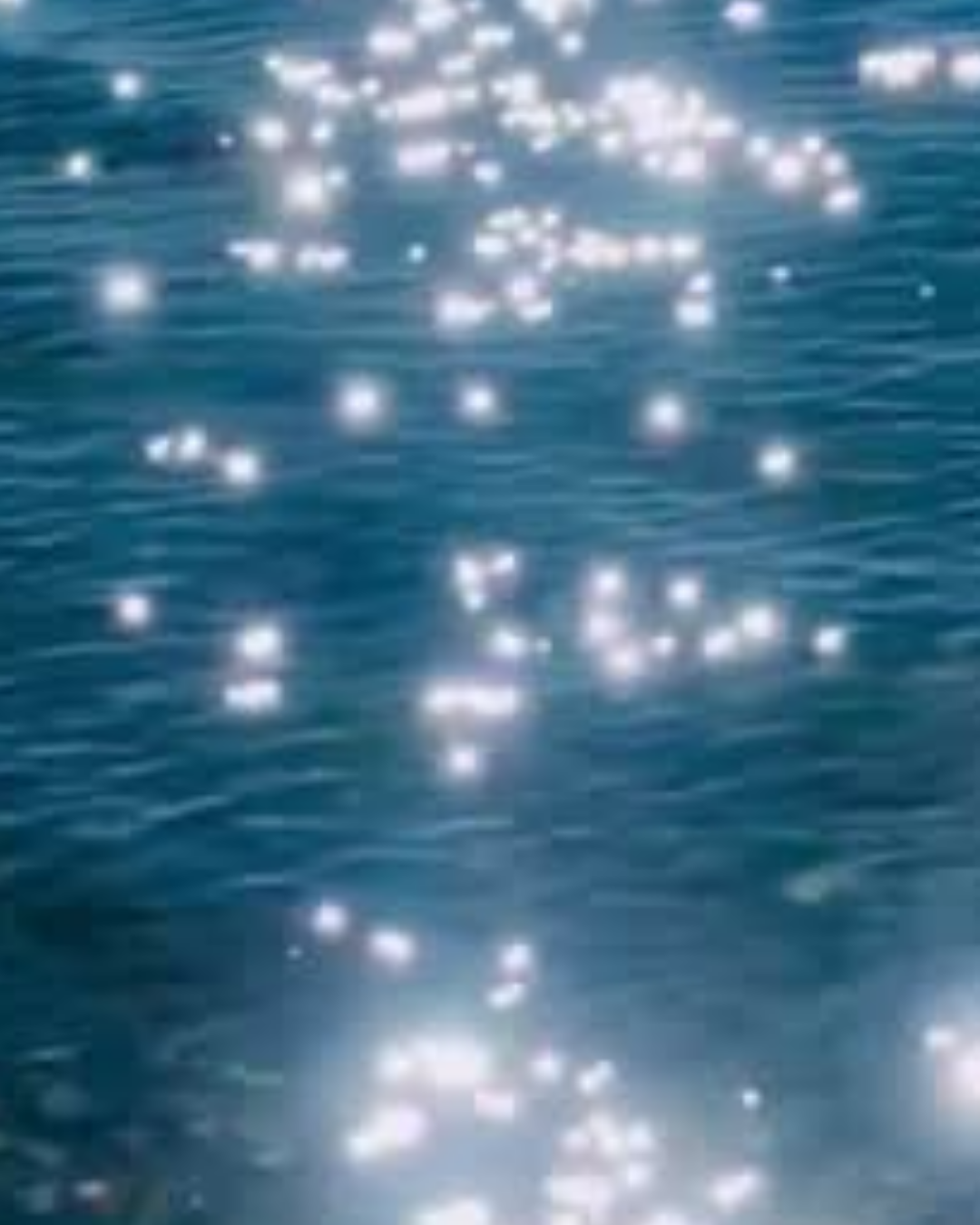 Sunlight reflecting off the surface of a blue body of water.