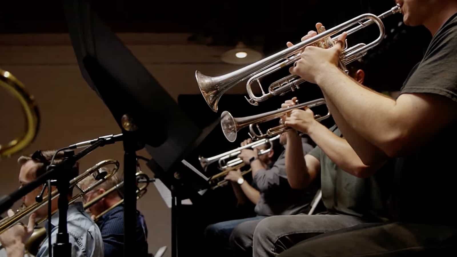 Jazz band musicians playing trumpets during a performance.