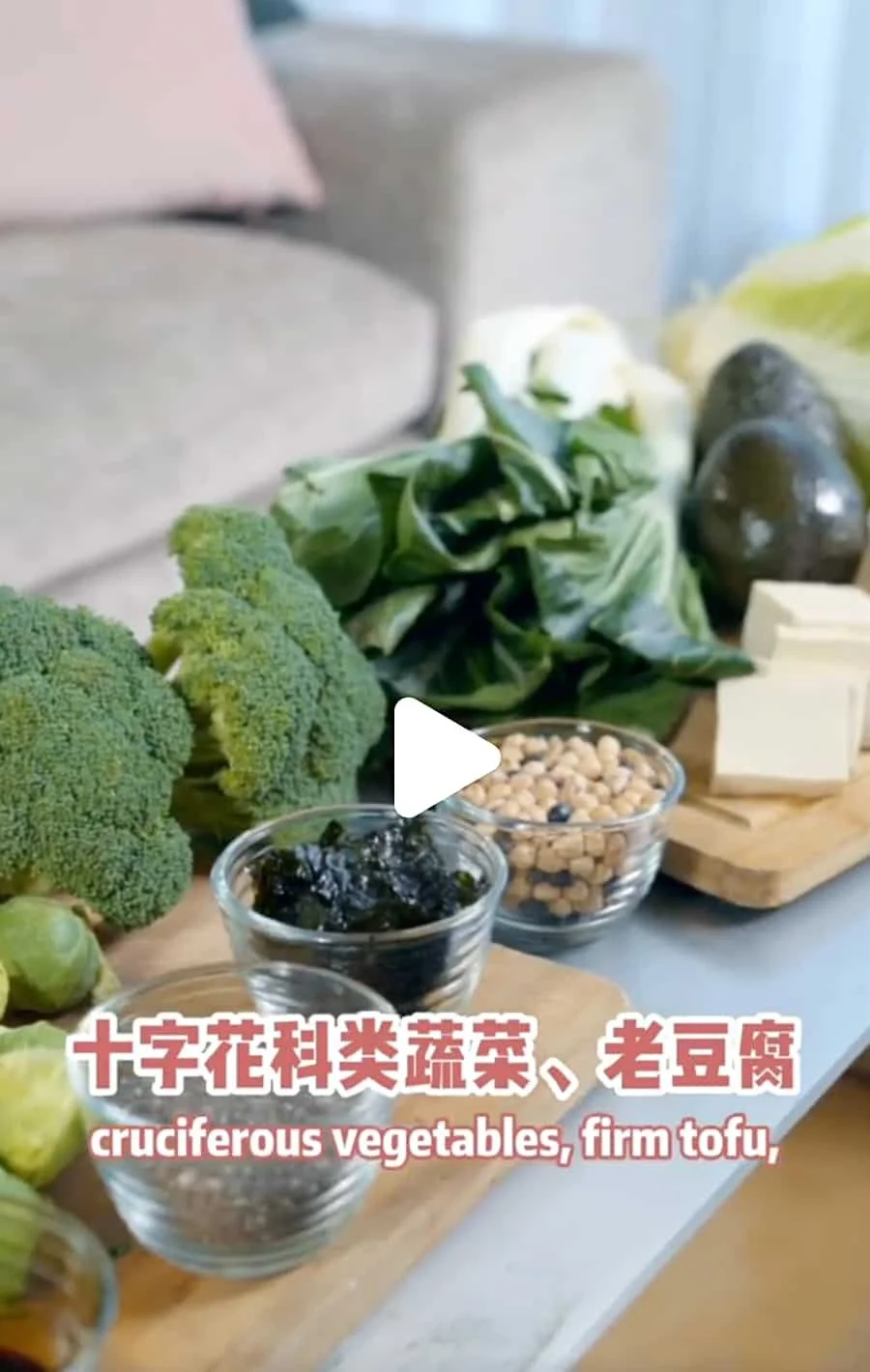 Assorted vegetables, tofu, chickpeas, and seaweed on a table, with Chinese and English captions describing them as 'cruciferous vegetables, firm tofu'.