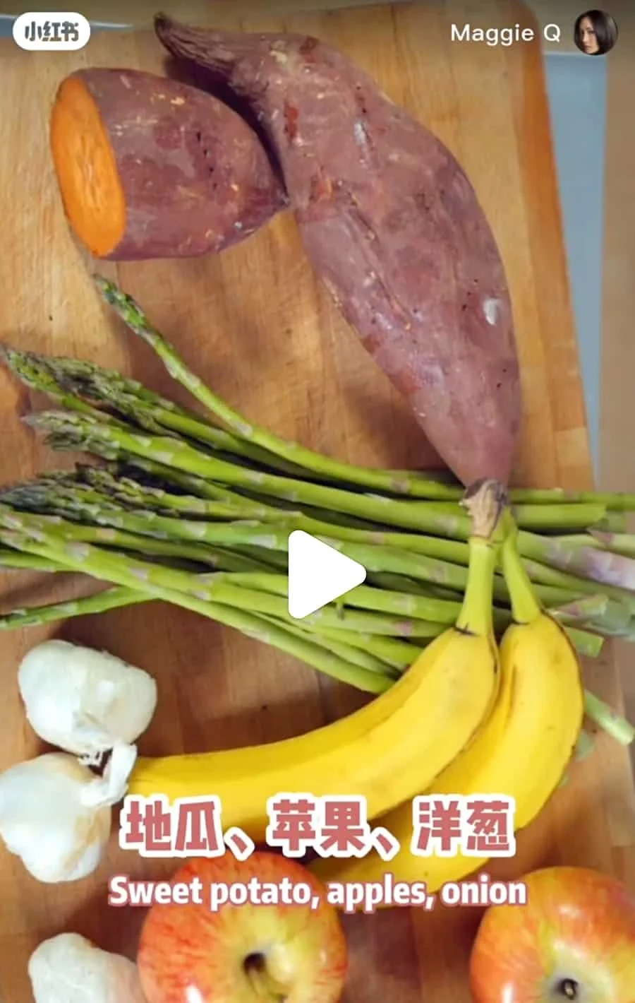 Sweet potato, apples, garlic, bananas, onions, asparagus on a wooden cutting board.