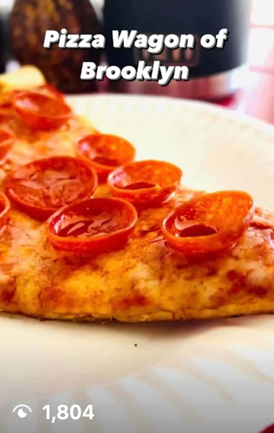 Close-up of a slice of pizza with pepperoni toppings on a white plate