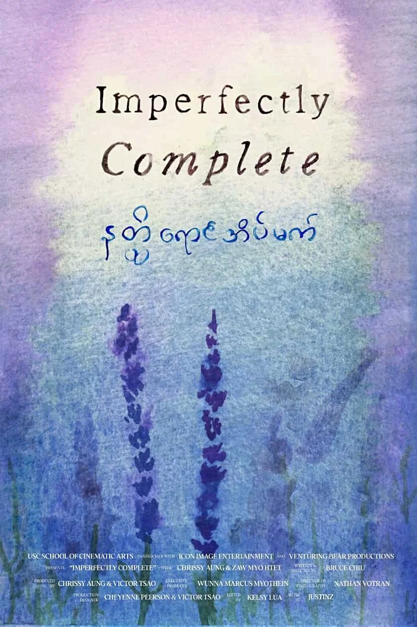 A poster for the film "Imperfectly Complete" featuring handwritten text in English and Burmese, with a watercolor background of purple, blue, and green lavender flowers at the bottom.