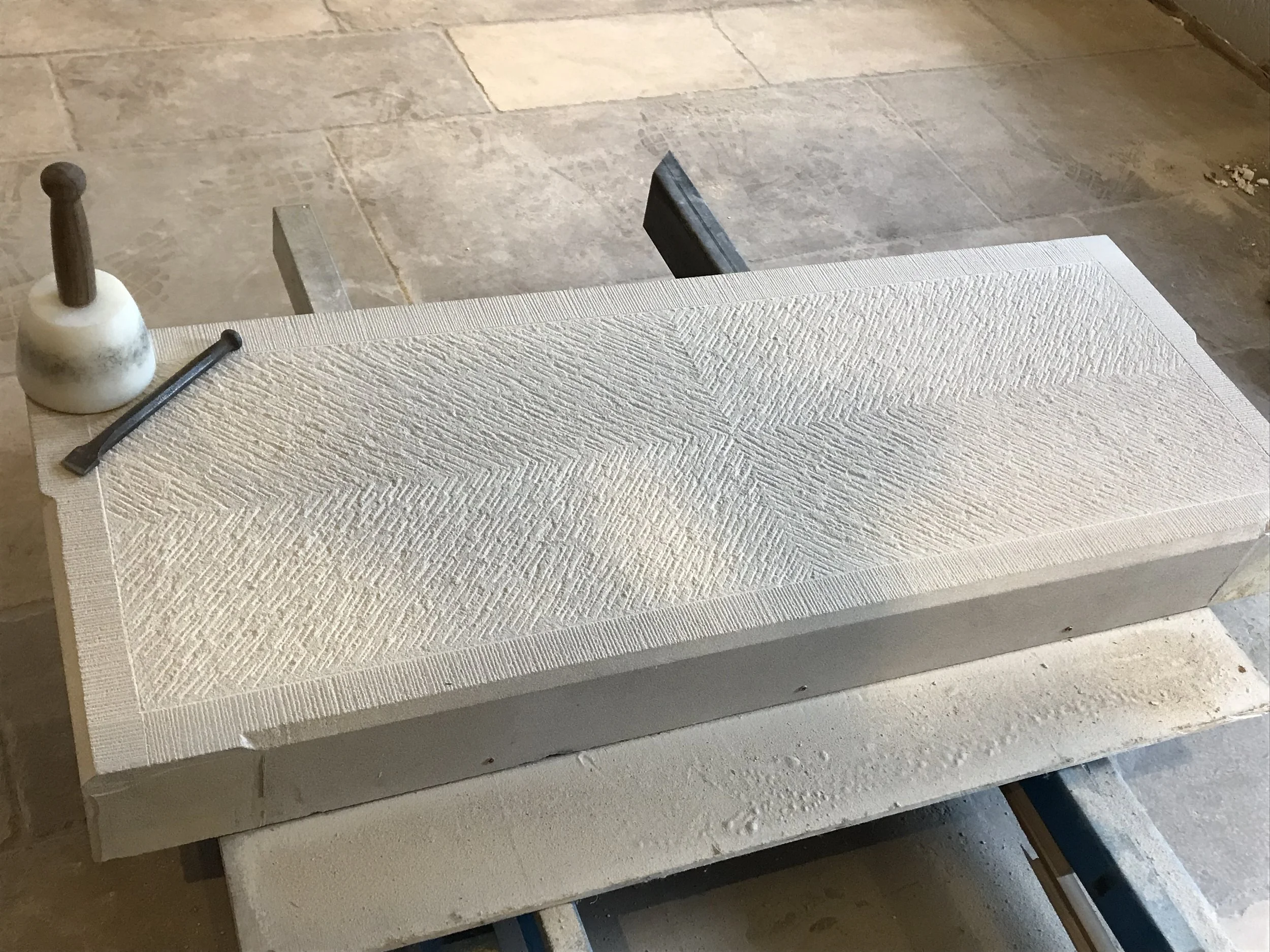A textured white sheet of material, possibly foam or insulation, resting on a flat surface with other construction or workshop items nearby.