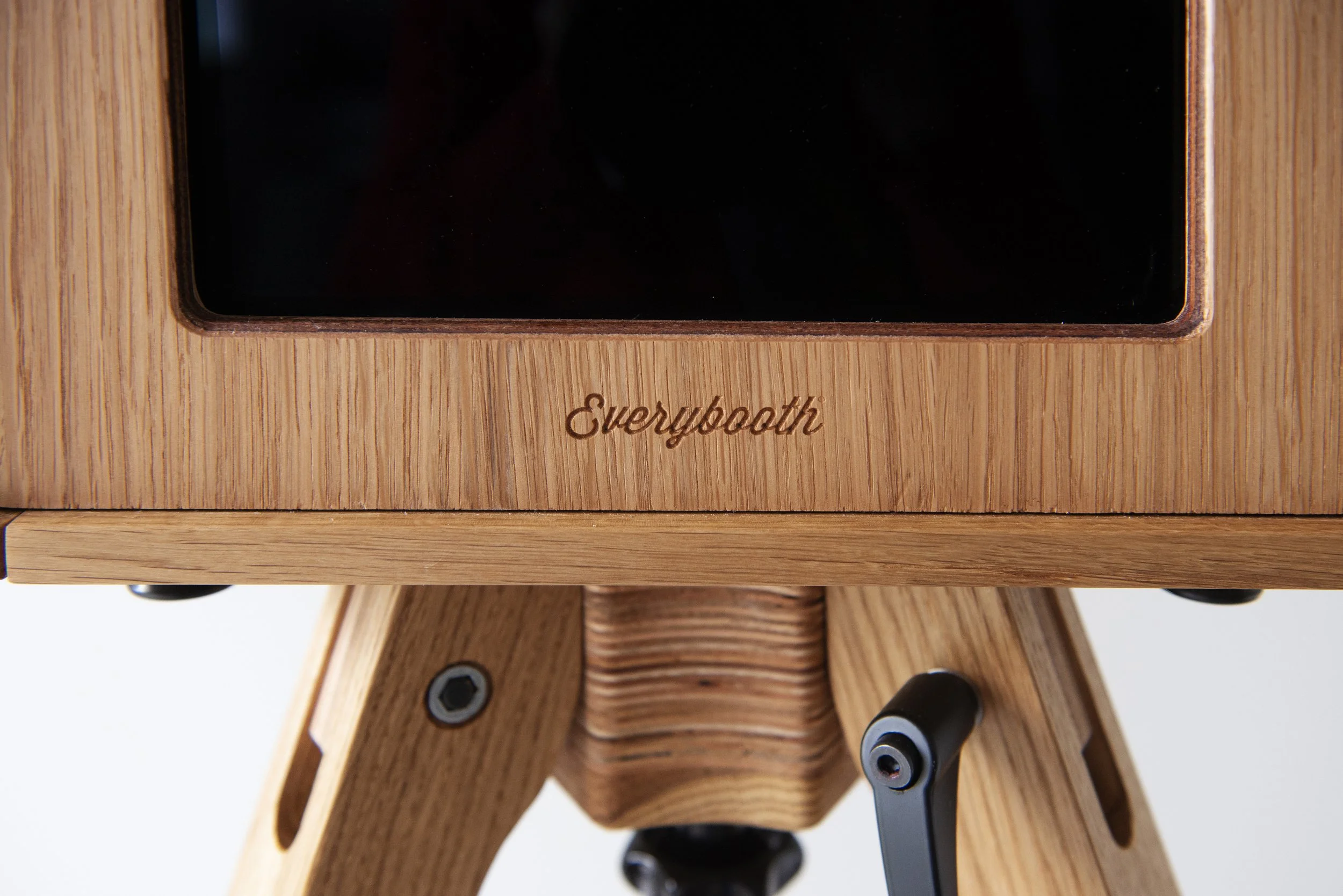 Close-up of a wooden electronic device labeled 'everyboard' with black knobs and a black screen on top.