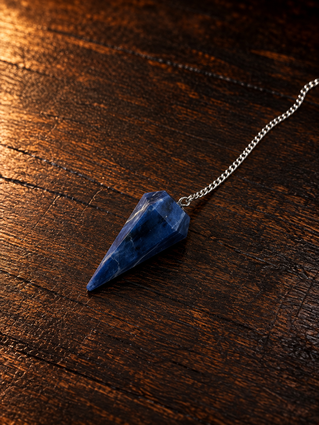 Blue Crystal Pendulum on Rustic Wood.png