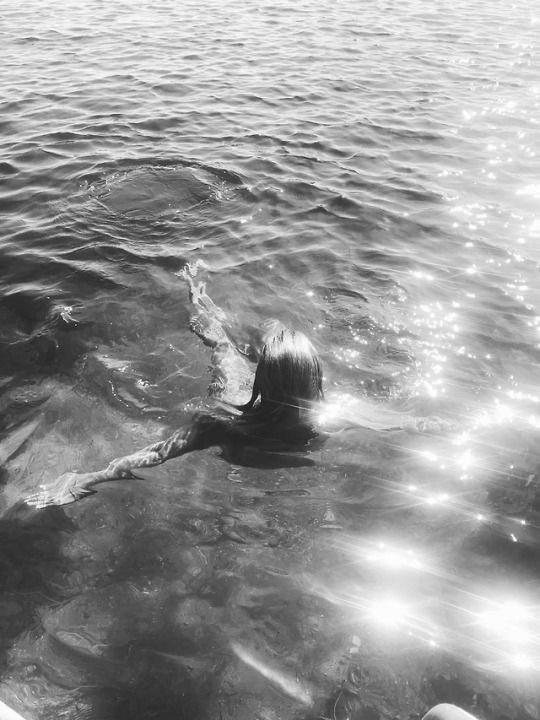 A person swimming in a body of water on a sunny day.