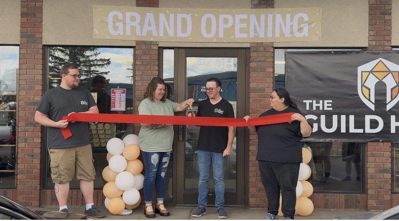 People participating in a ribbon-cutting ceremony for The Guild Hall.