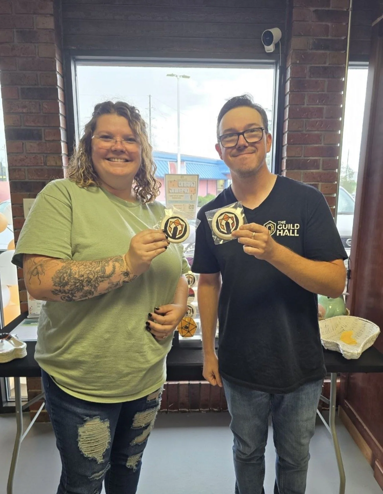 Owners of The Guild Hall posing with their cookies made by Blossom and Bite on their Grand Opening Day.