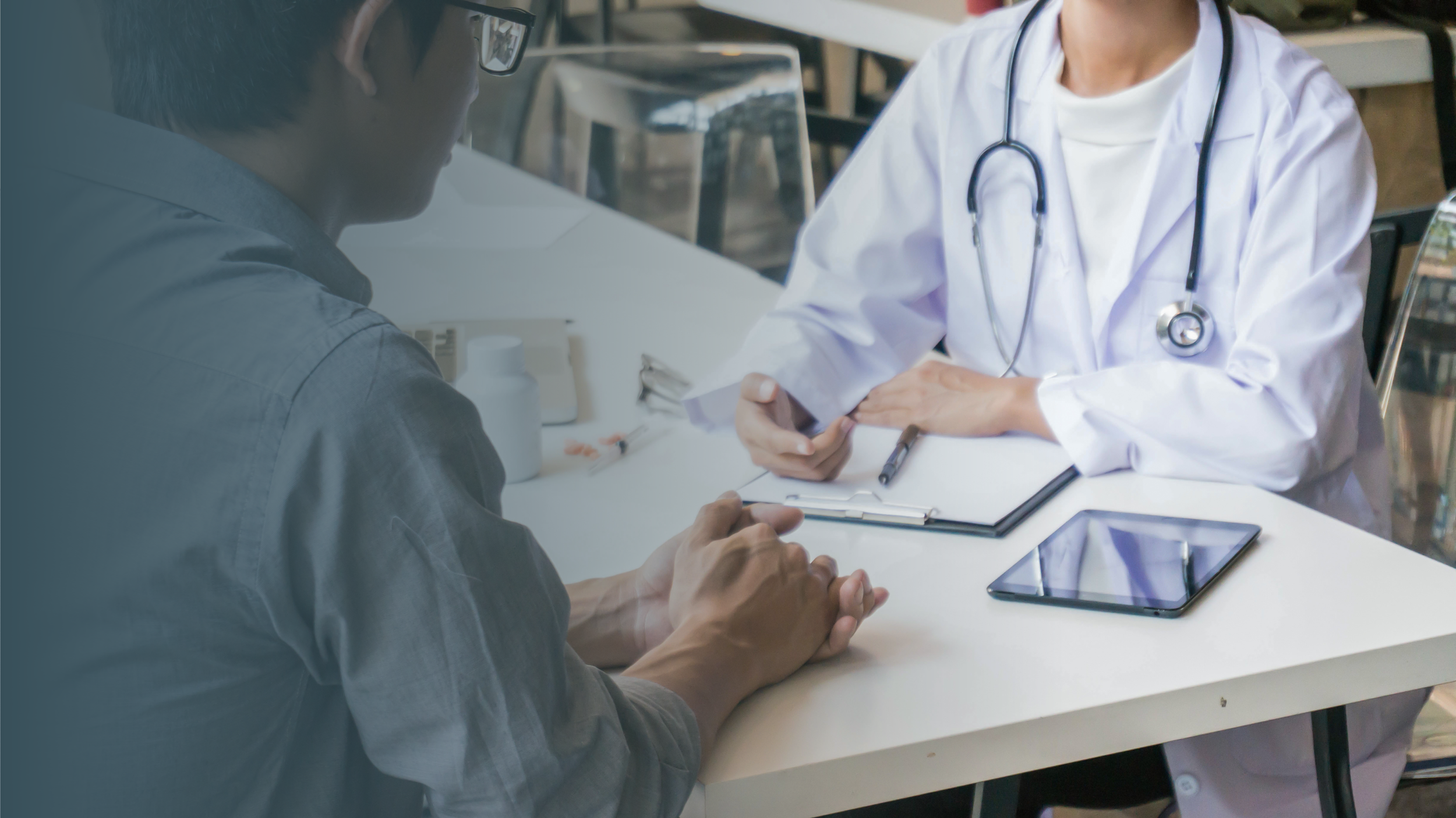 A doctor in a white coat and stethoscope consulting with a patient in a medical setting, with a clipboard, syringe, tablets, and bottle on the table.