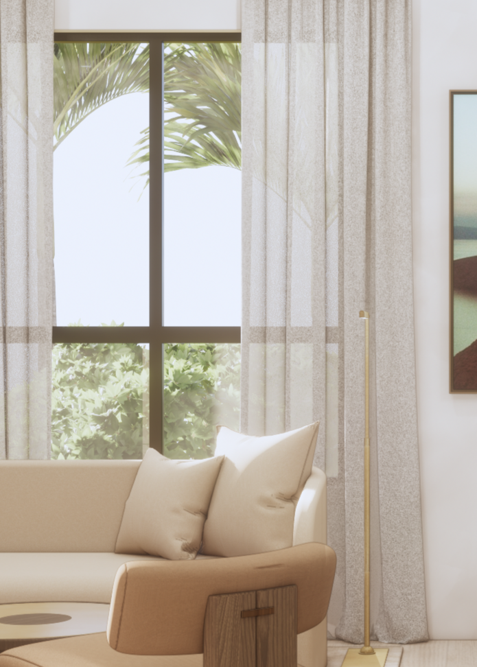 Living room with large window showing green foliage and palm tree outside, beige sofa with two pillows, and a tall, thin, gold-colored floor lamp.