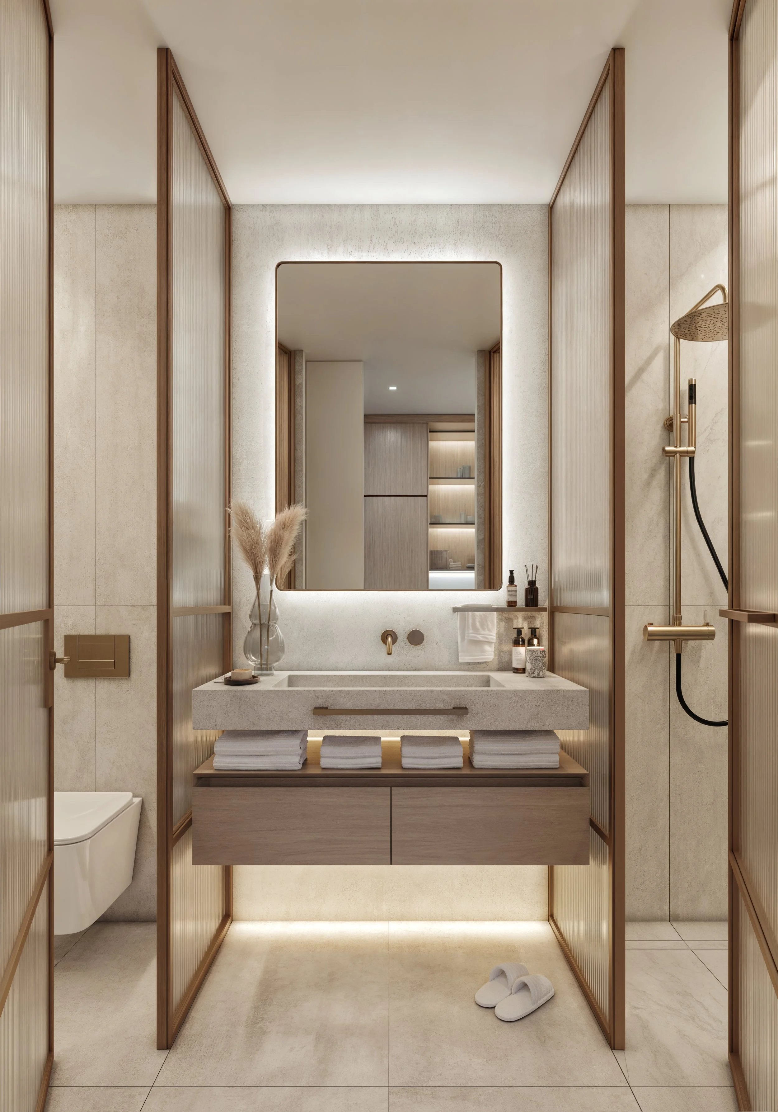 Modern bathroom with a large framed mirror, a beige sink with organized toiletries and towels, a glass vase with pampas grass, and a walk-in shower with a ceiling rain shower head. The room features beige walls, sleek cabinetry, and is illuminated with soft lighting.