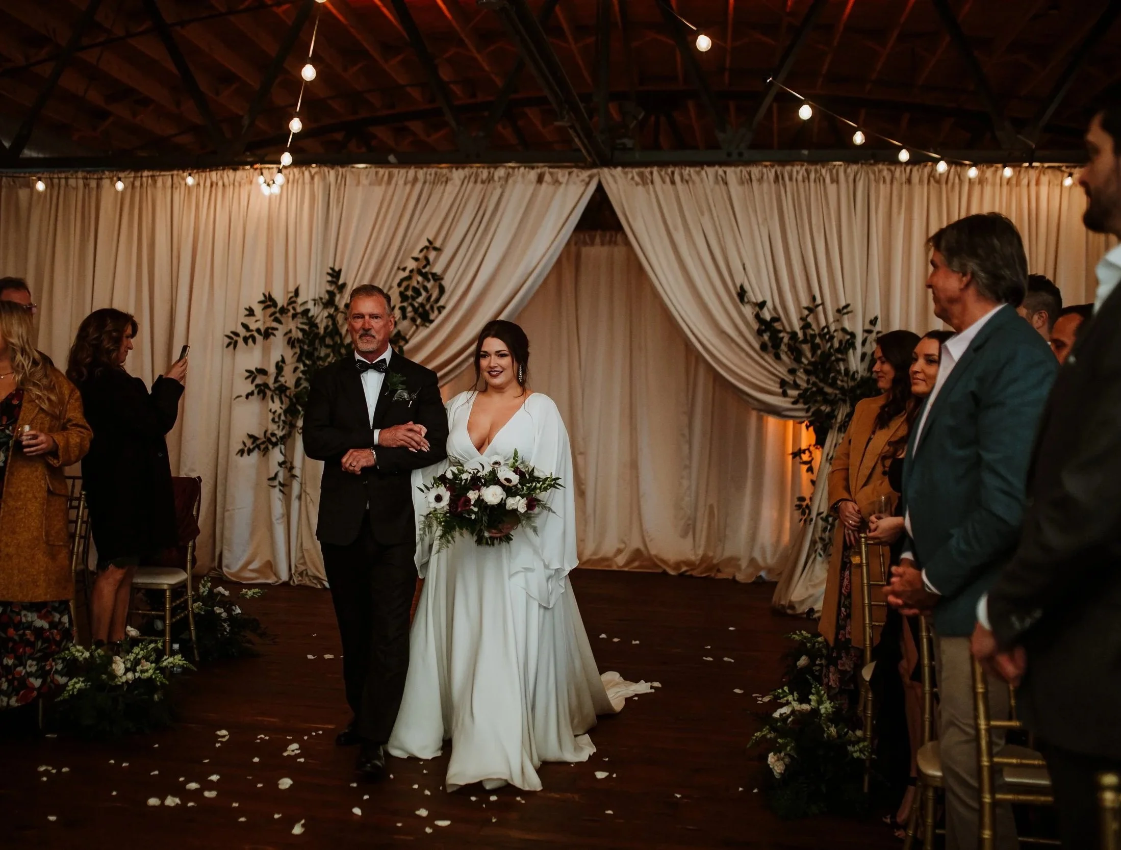 A bride and groom walking down the aisle at their wedding ceremony with guests on either side.