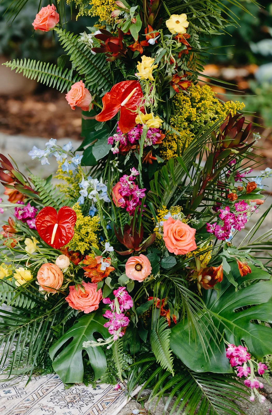 A colorful tropical flower arrangement with various flowers and lush green foliage.