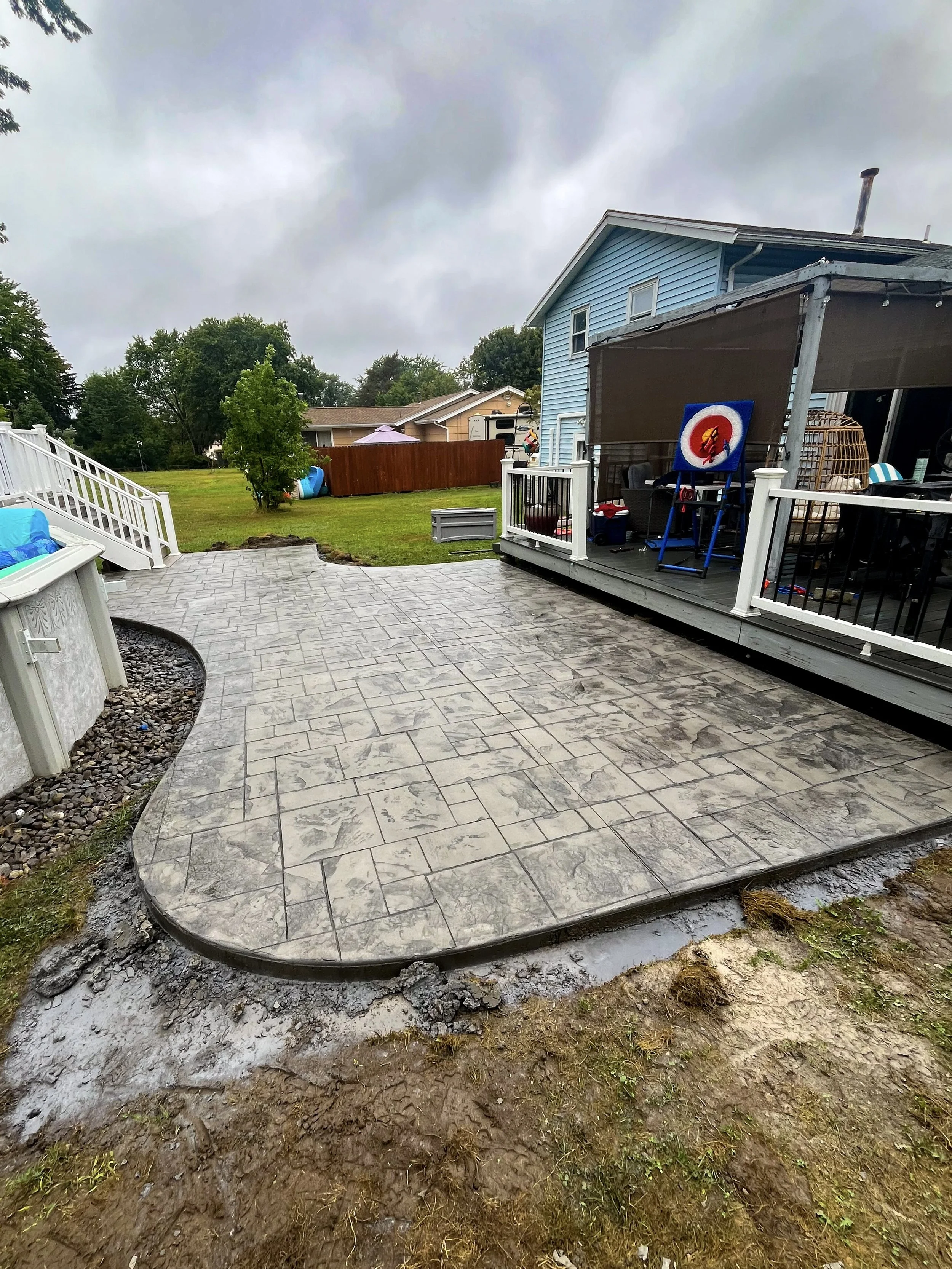 Curved stamped patio near a pool