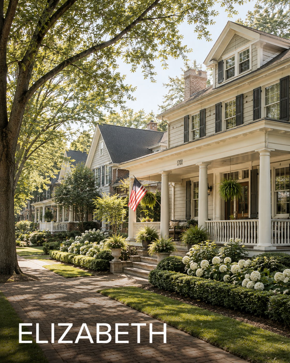 A row of charming houses with front porches, lush landscaping, and white hydrangeas lining the sidewalk. The house in the foreground has an American flag displayed on the porch.