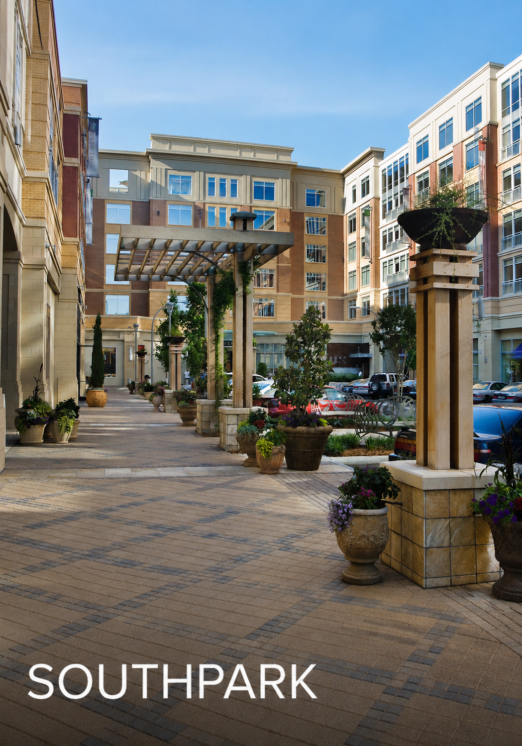 Photo of an outdoor courtyard area in a modern apartment complex with potted plants, benches, and a covered walkway, labeled 'SOUTHPARK' at the bottom.