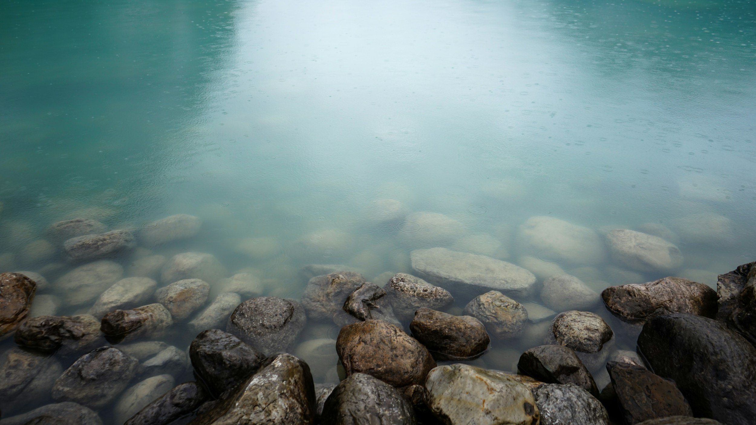 Clear water with small rocks along the shore.