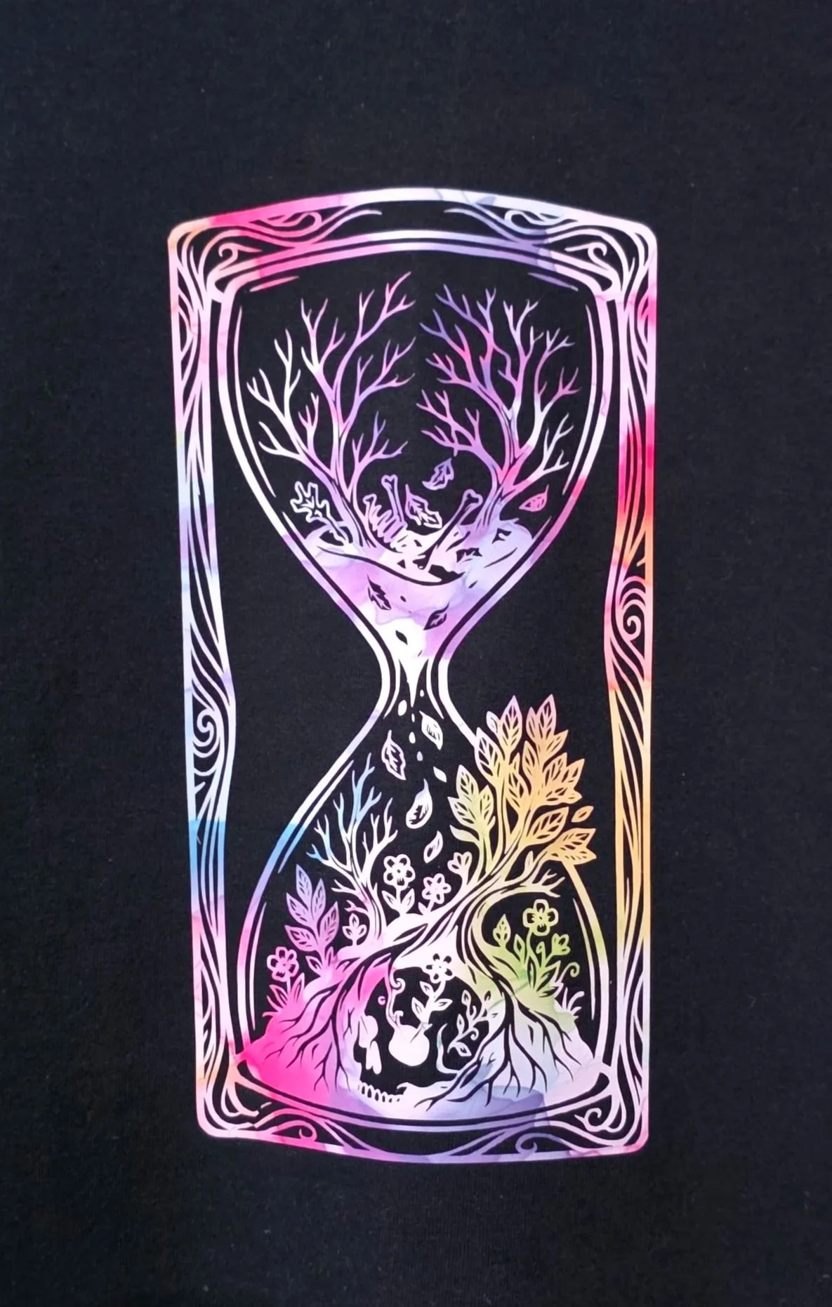 Black T-shirt with a colorful, holographic-style design of an hourglass filled with trees and nature scenes.