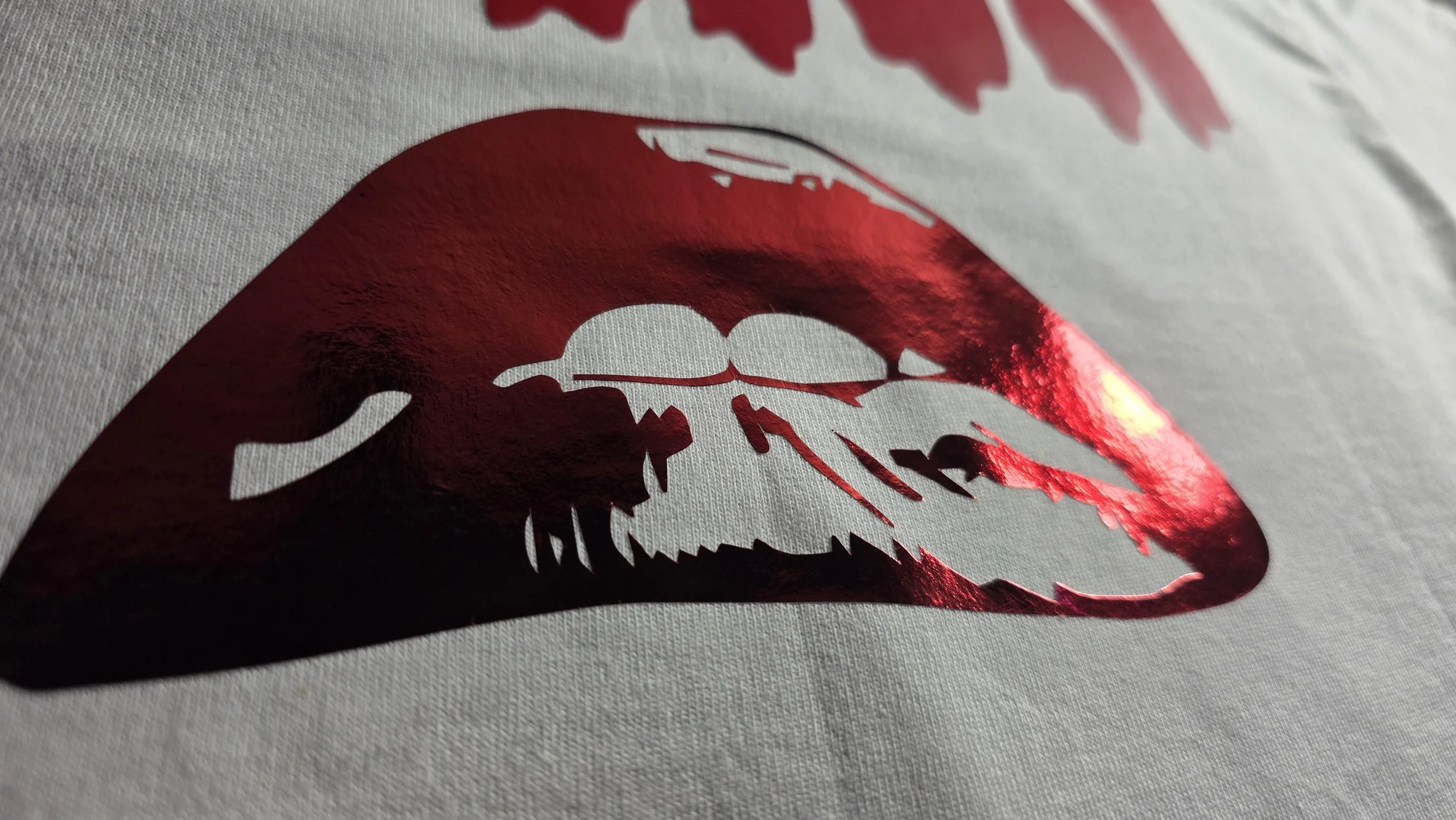 Close-up of a metallic red Rocky Horror Picture Show lips from the back of the shirt