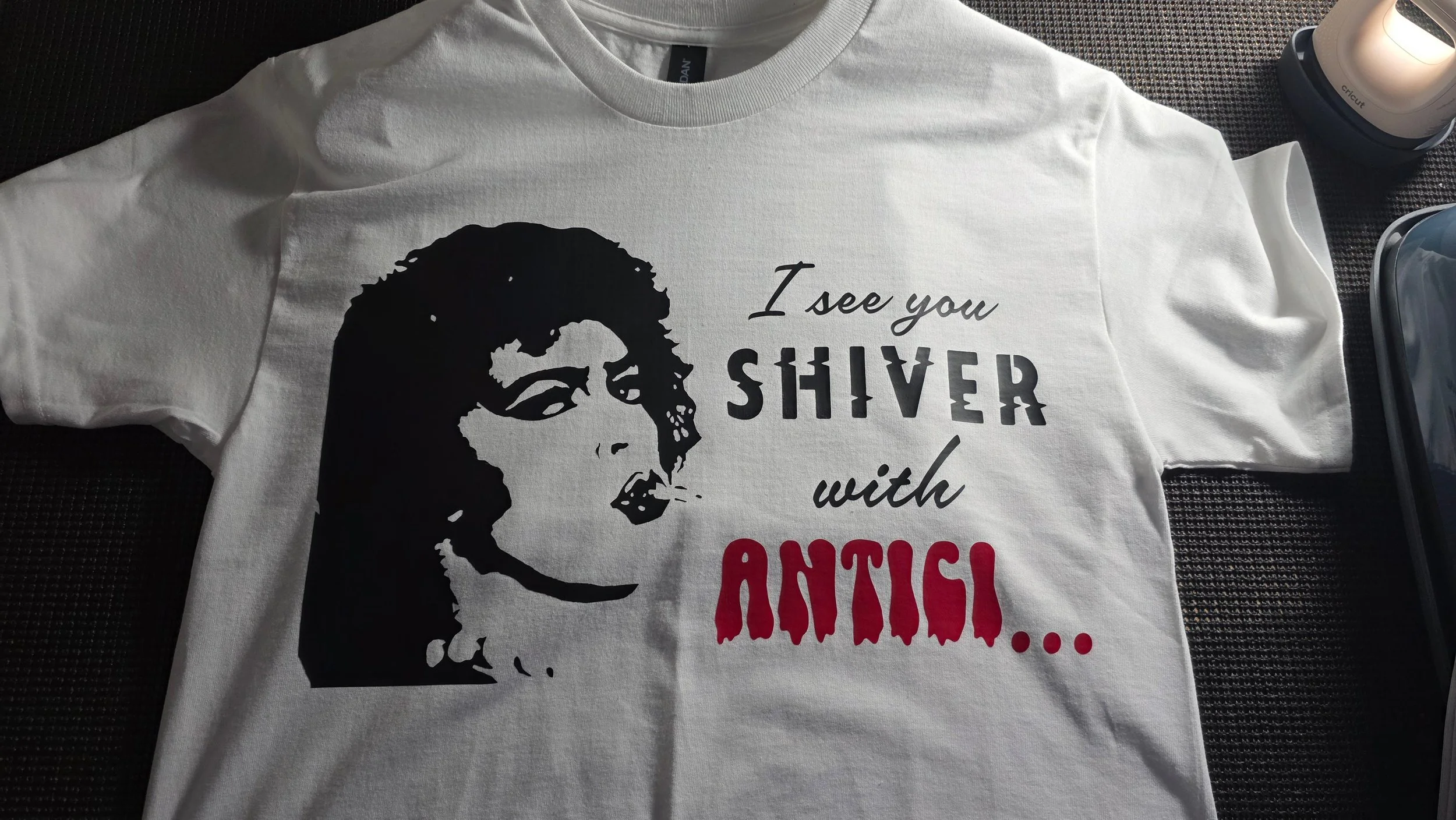 White T-shirt with a black graphic of a woman's face and the text 'I see you shiver with...' in black and red letters.