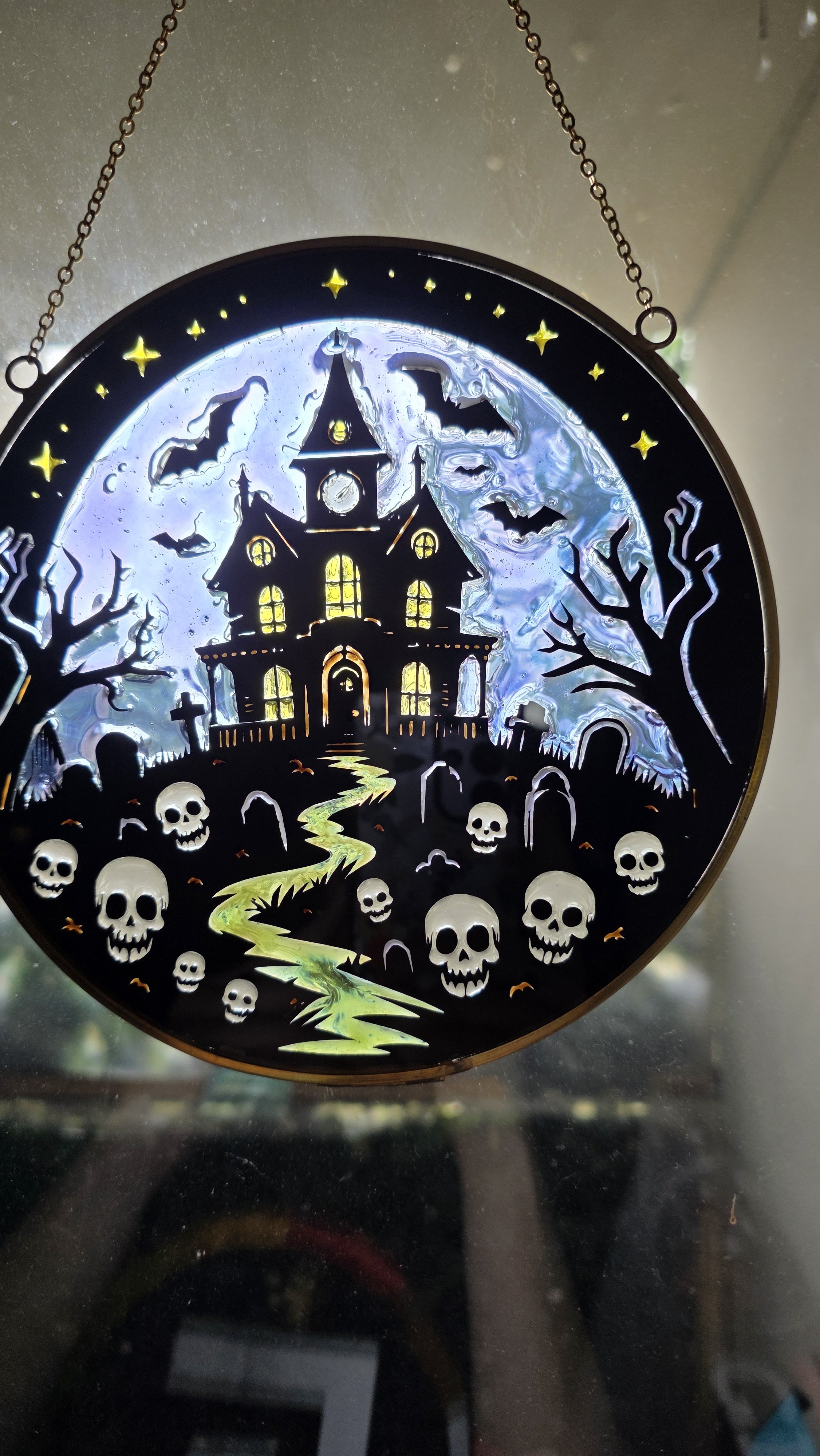 Halloween-themed haunted house with bats, skulls, leafless trees, a spooky path, and a full moon.
