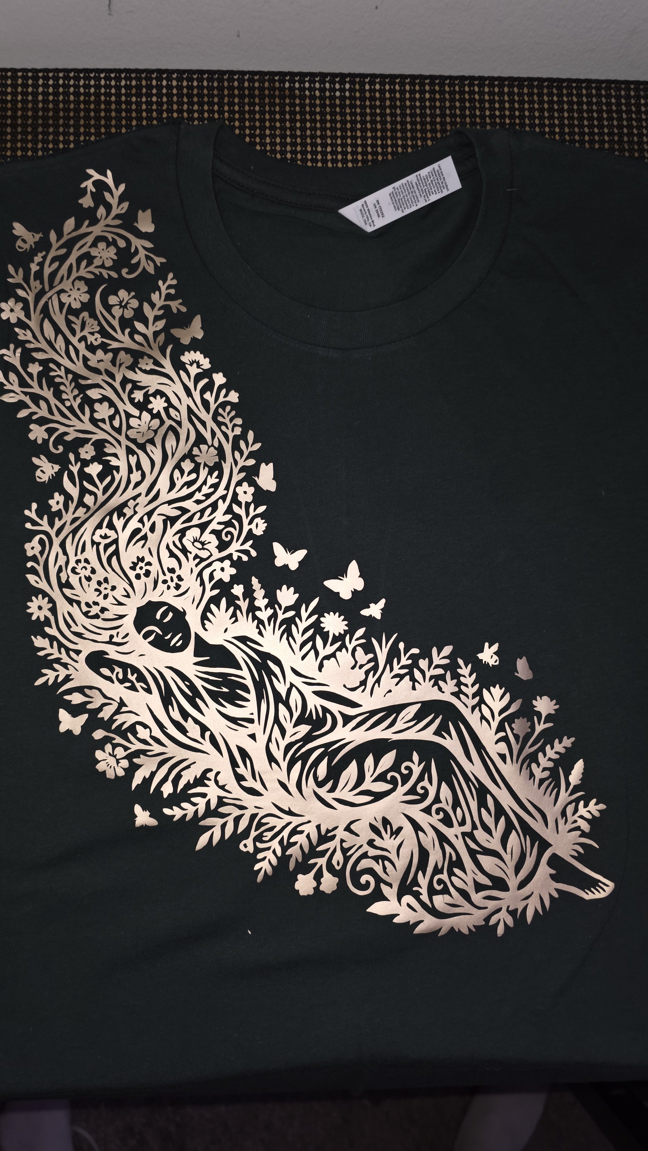 Black t-shirt with a golf intricate design of Mother Nature with long flowing hair made of flowers and butterflies.