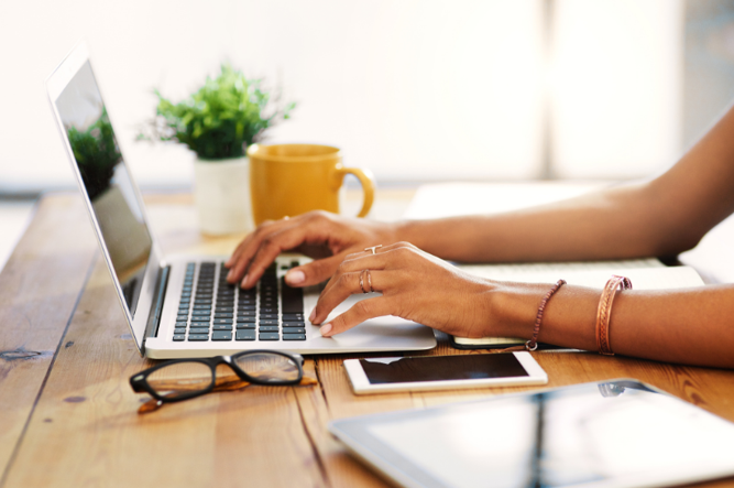 Client typing an inquiry about curriculum review services at a sunlit desk