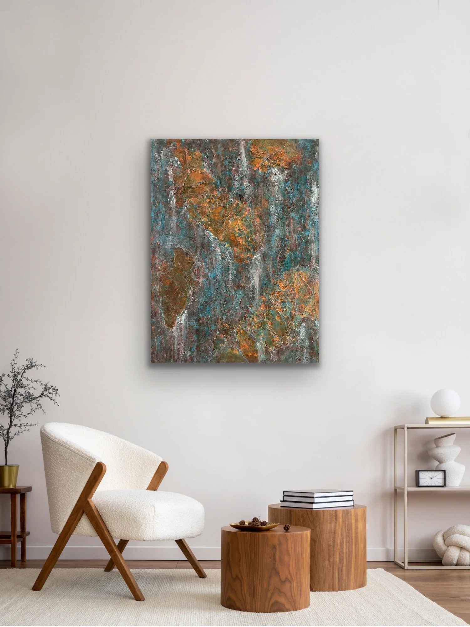 Modern living room with white walls, an orange and blue abstract painting on the wall, a white armchair, a small side table with books, and two round wooden stools with a tray and decor items, minimalist style.