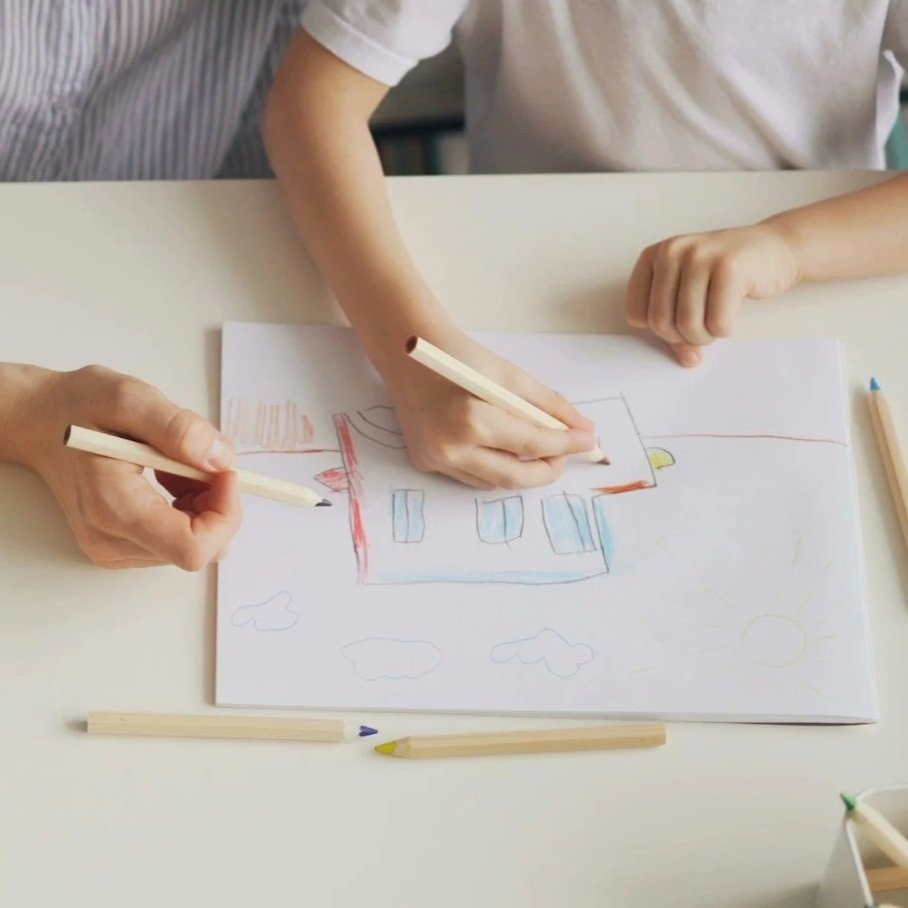 A parent and child drawing together during a filial play therapy session