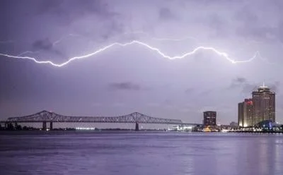 Lightning strike over city skyline and river at night
