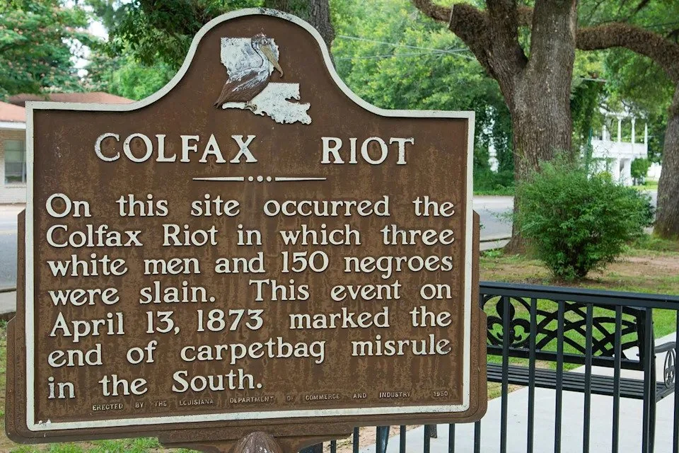 Historical marker about the Colfax Riot stating that it occurred on April 13, 1873, where three white men and 150 African Americans were killed. The event marked the end of a carpetbag misrule in the South.