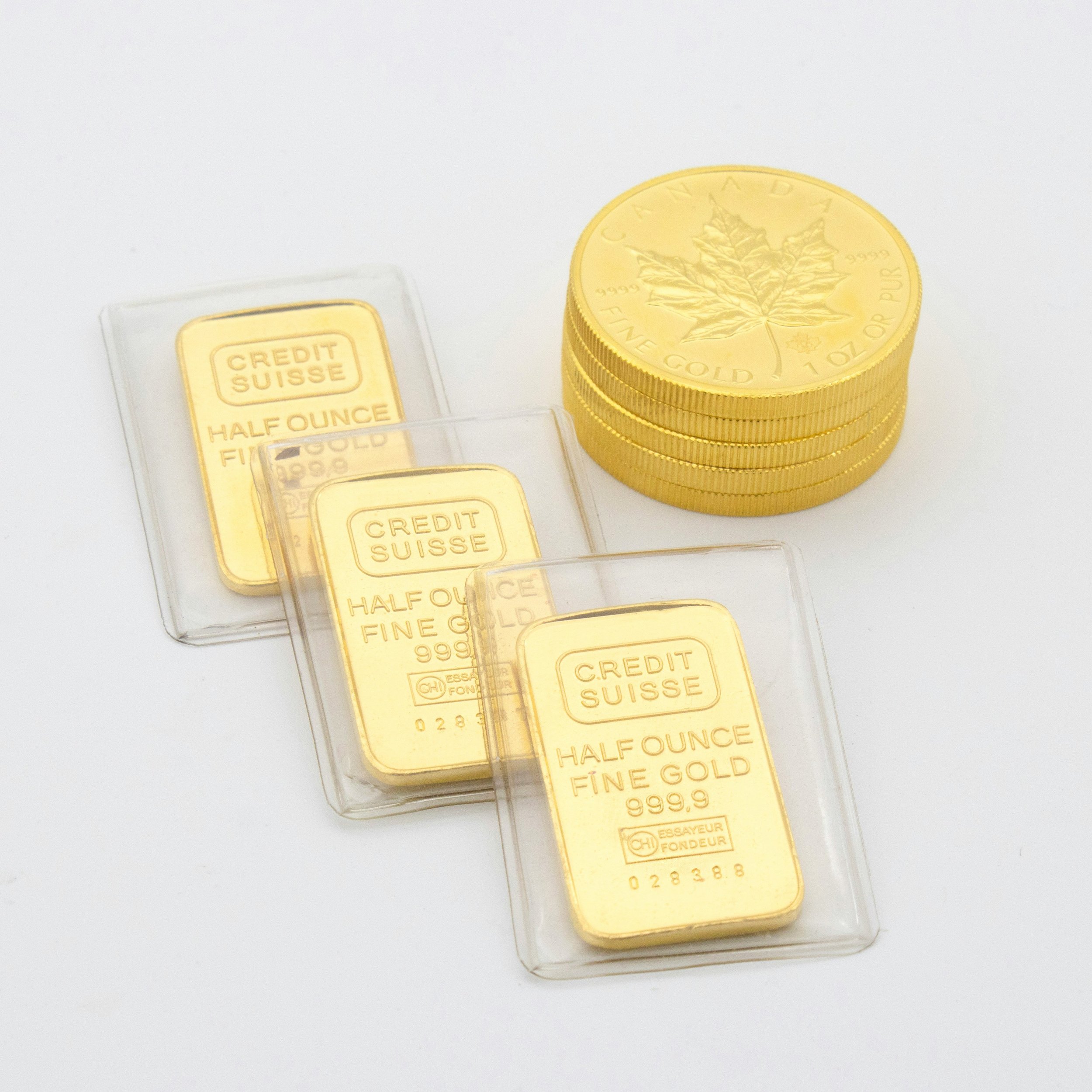 Une pile de pièces d'or en forme de lingots et un petit emballage de lingot d'or.