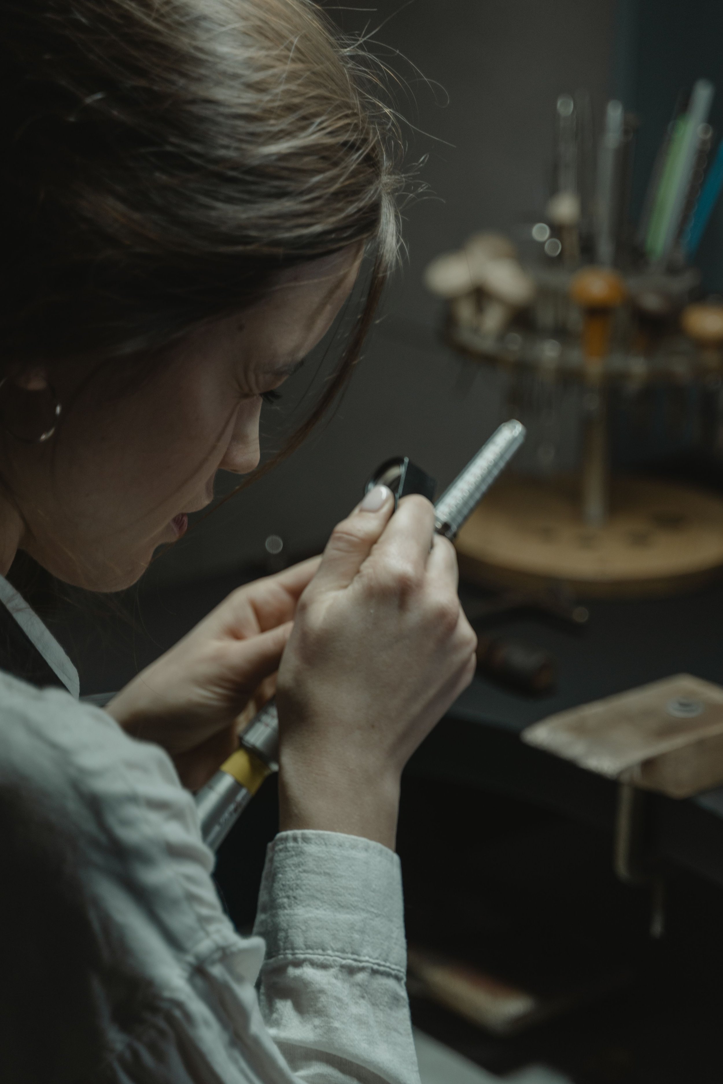 Femme vue de profil utilisant un compteur de telescopie dans un espace intérieur. Décoration avec des champignons et un support à crayons en arrière-plan.